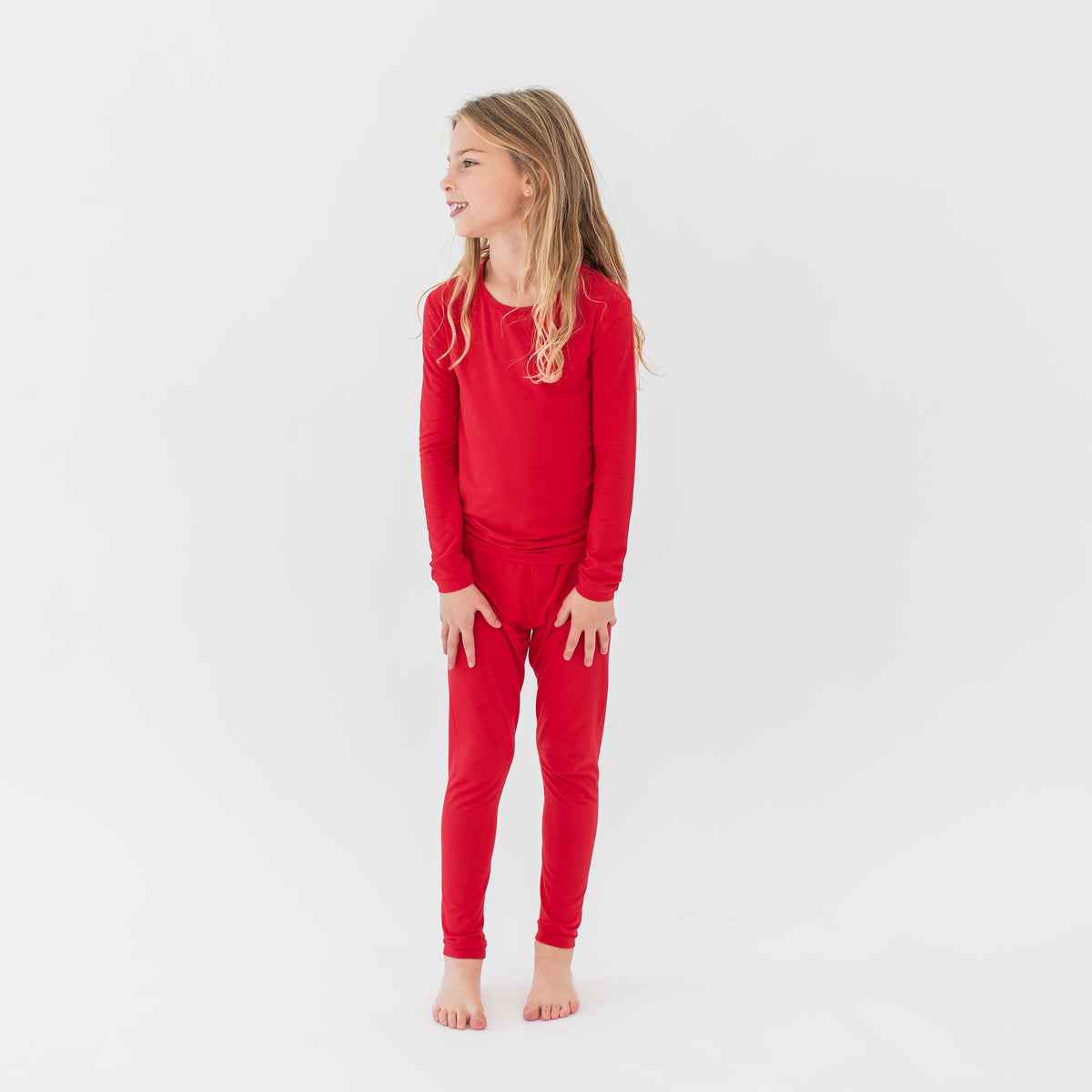 Young girl wearing the Long Sleeve Pajamas in Cardinal in front of a white background