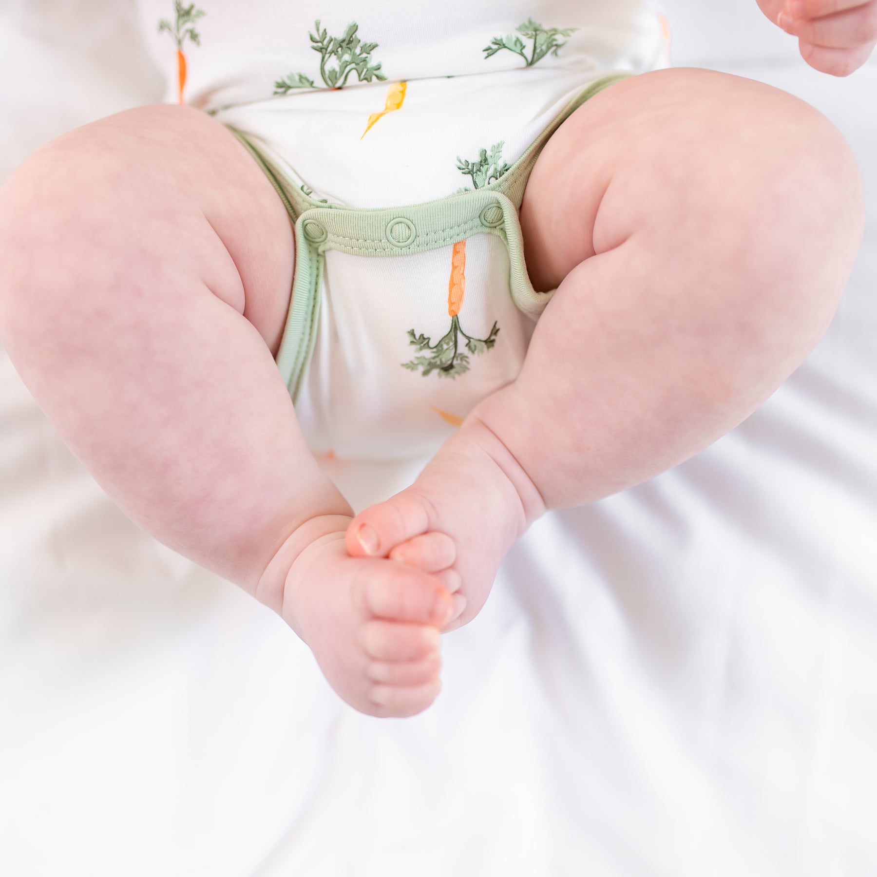 Close up of the snap closures on the Bodysuit in Carrot