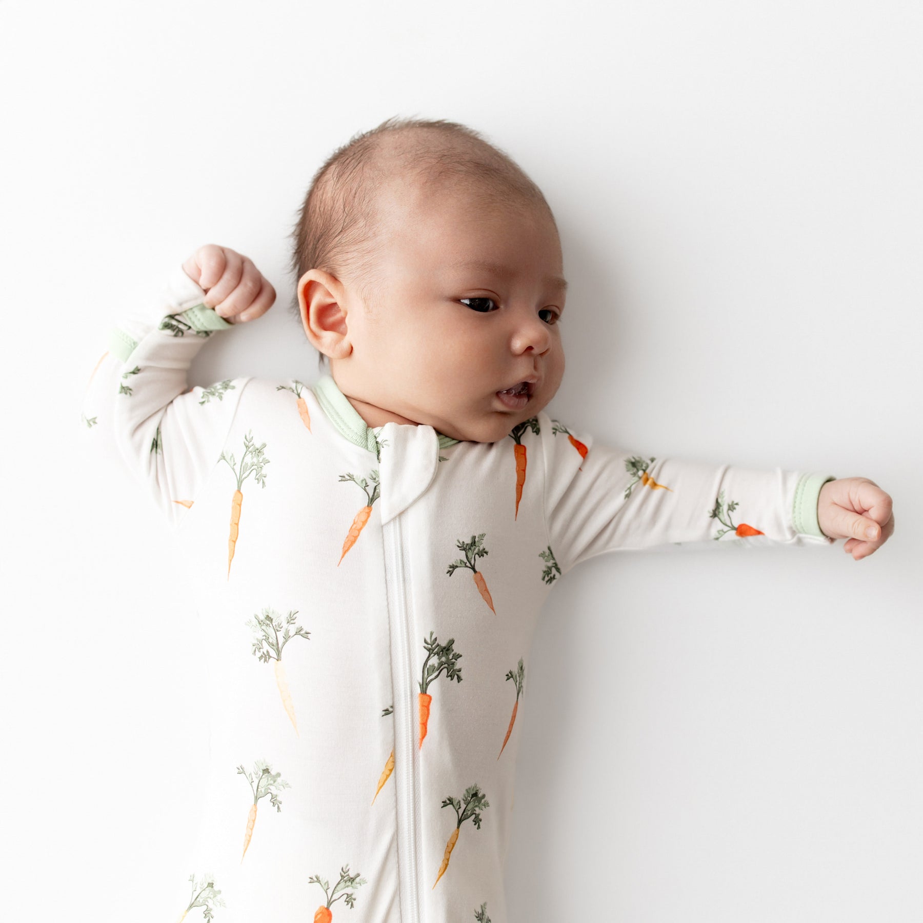 Close up of newborn wearing the Zippered Footie in Carrot