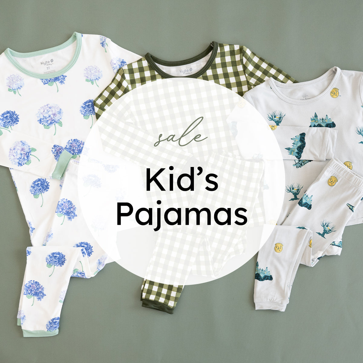 Three children's pajama sets arranged on a muted green background with a large white circular overlay reading 'sale Kid's Pajamas.' The left set is white with blue floral prints and pale green trim; the center set is white and olive green gingham; the right set is white with blue and yellow tropical-style prints.