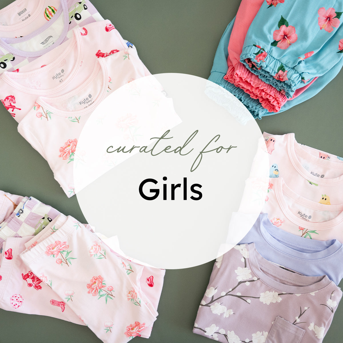 A styled flat-lay of multiple folded girls' pajamas in pastel colors with floral and cartoon prints, arranged around a large white circular overlay that reads 'curated for Girls' on a muted green background.