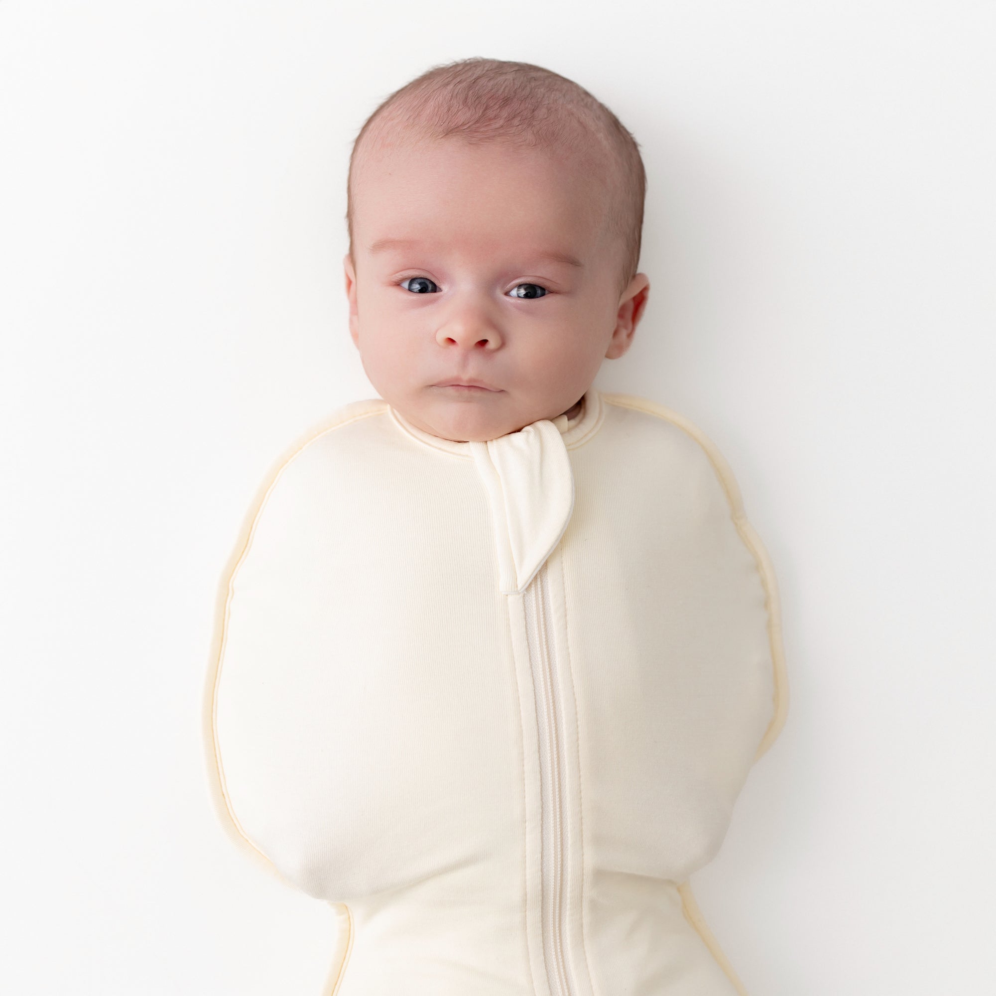Close up of a newborn wearing the Swaddle Bag in Chamomile 0.5