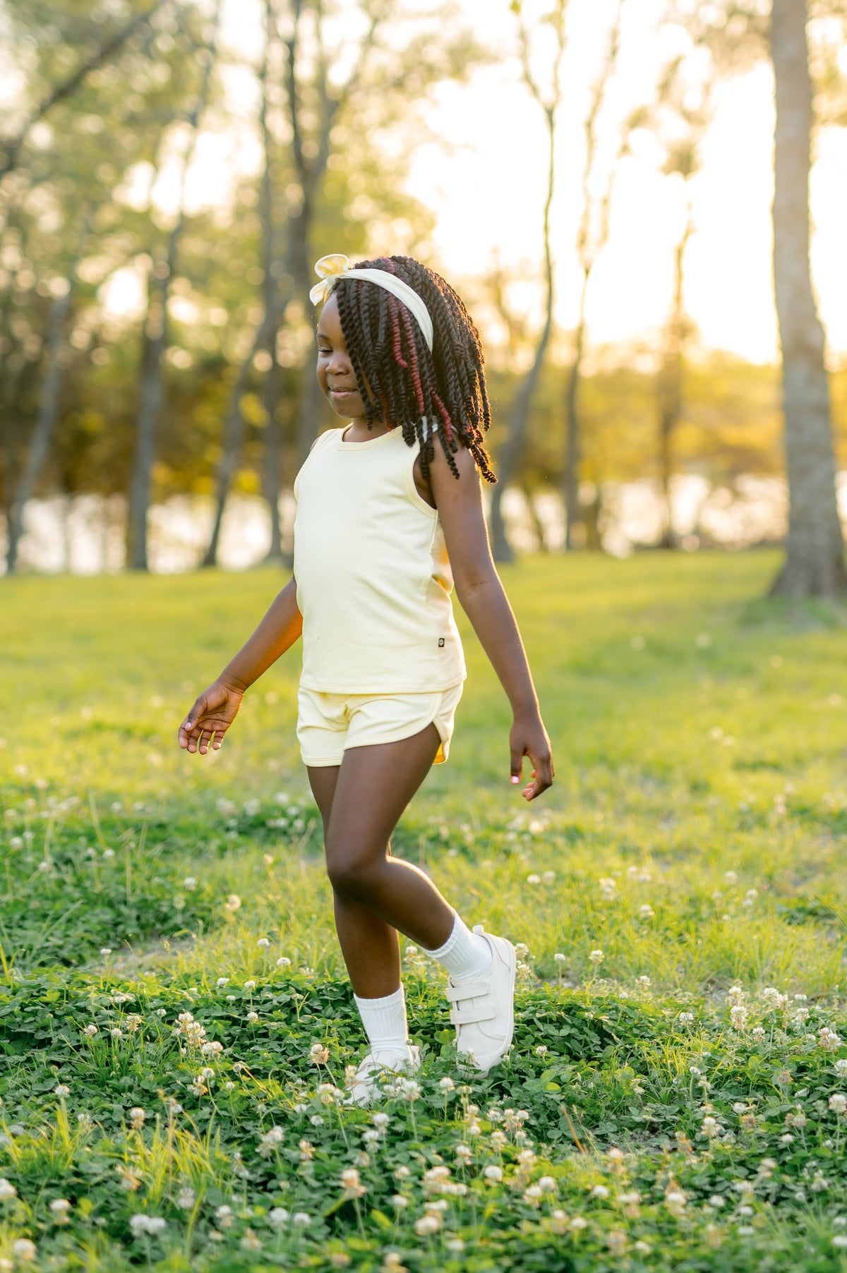 Young girl walking through a field wearing the Tank Jogger Set in Chamomile