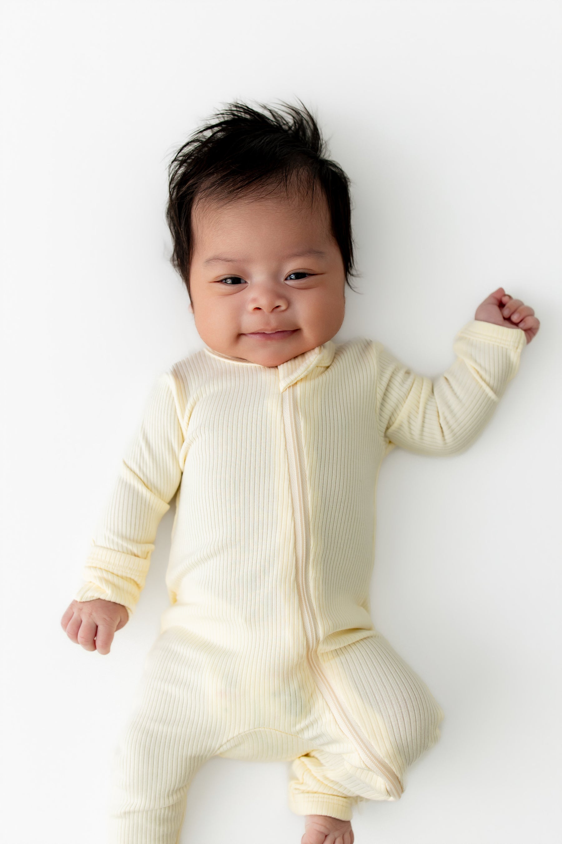Close up of the Ribbed Zipper Romper in Chamomile shown on a newborn