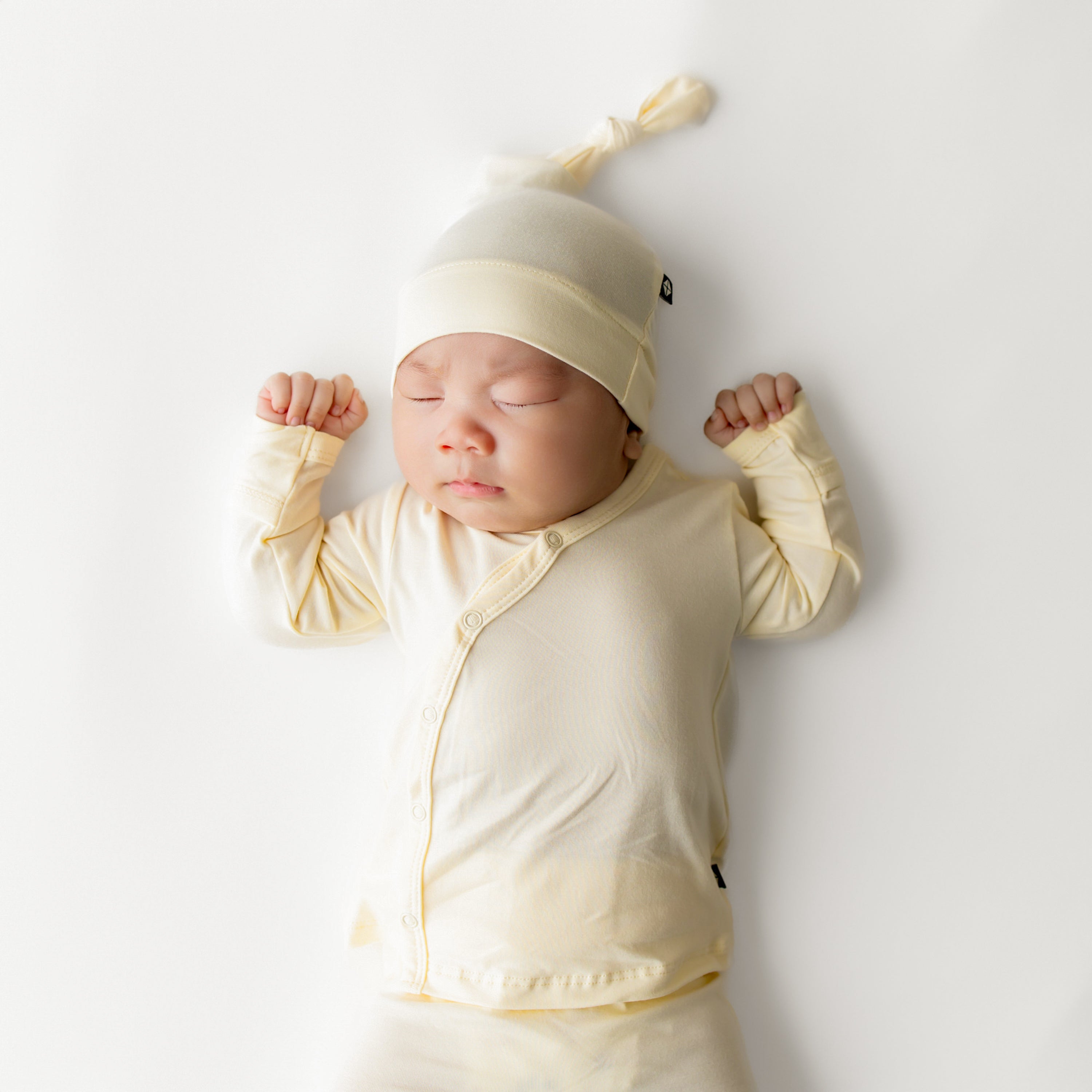 Close up of sleeping infant wearing the Take Me Home Set with Cap in Chamomile