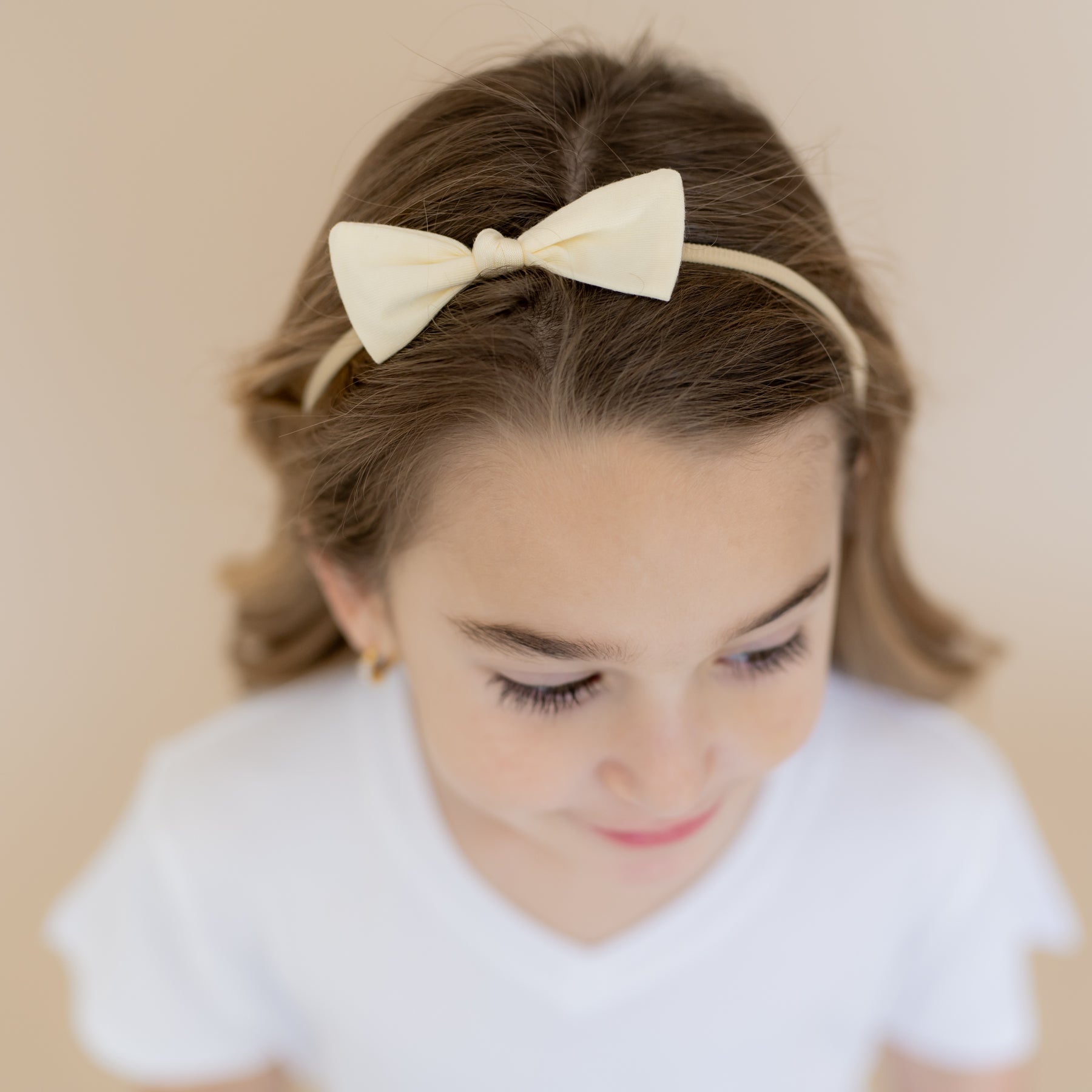 Tiny Nylon Bow in Chamomile shown in a young girls hair