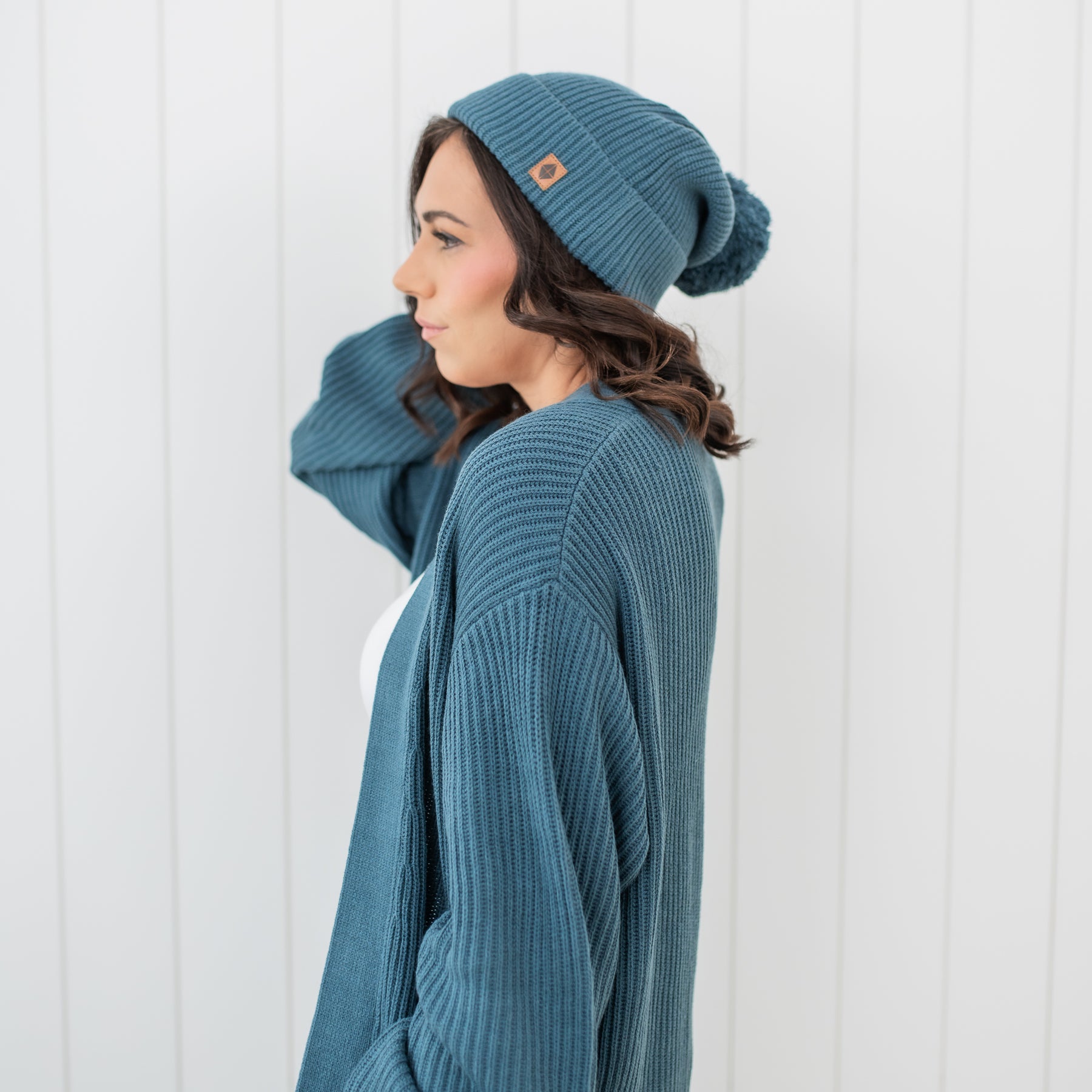 Female modeling the Chunky Knit Adult Pom Beanie in Atlantic paired with a matching Chunky Knit Women's oversized cardigan