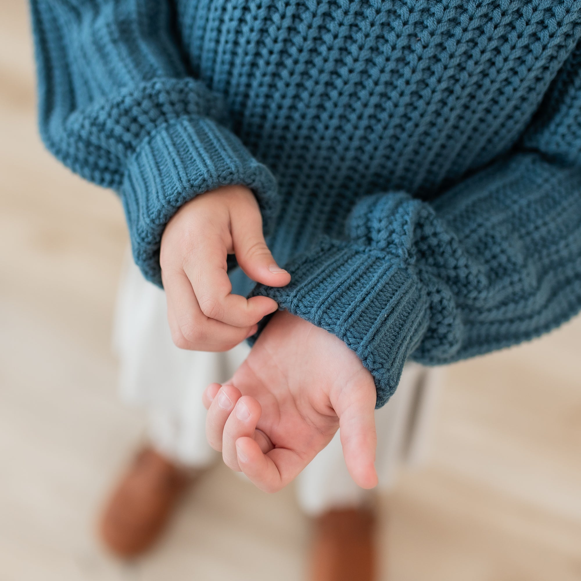 Close up of the wrist cuffs and knit fabric on the Chunky Knit Sweater in Atlantic