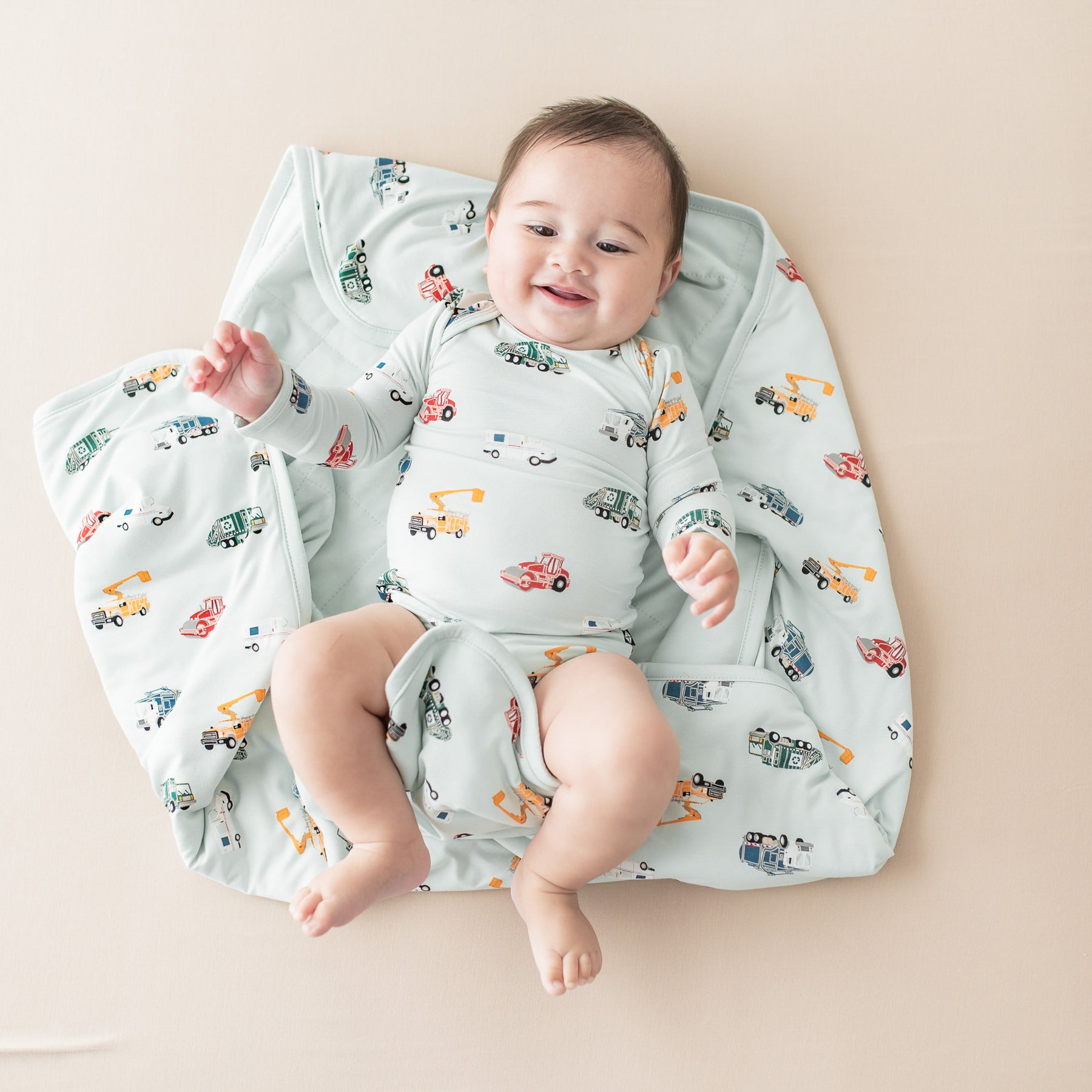 Infant laying on a Baby Blanket in City Vehicles 1.0 wearing a matching long sleeve bodysuit