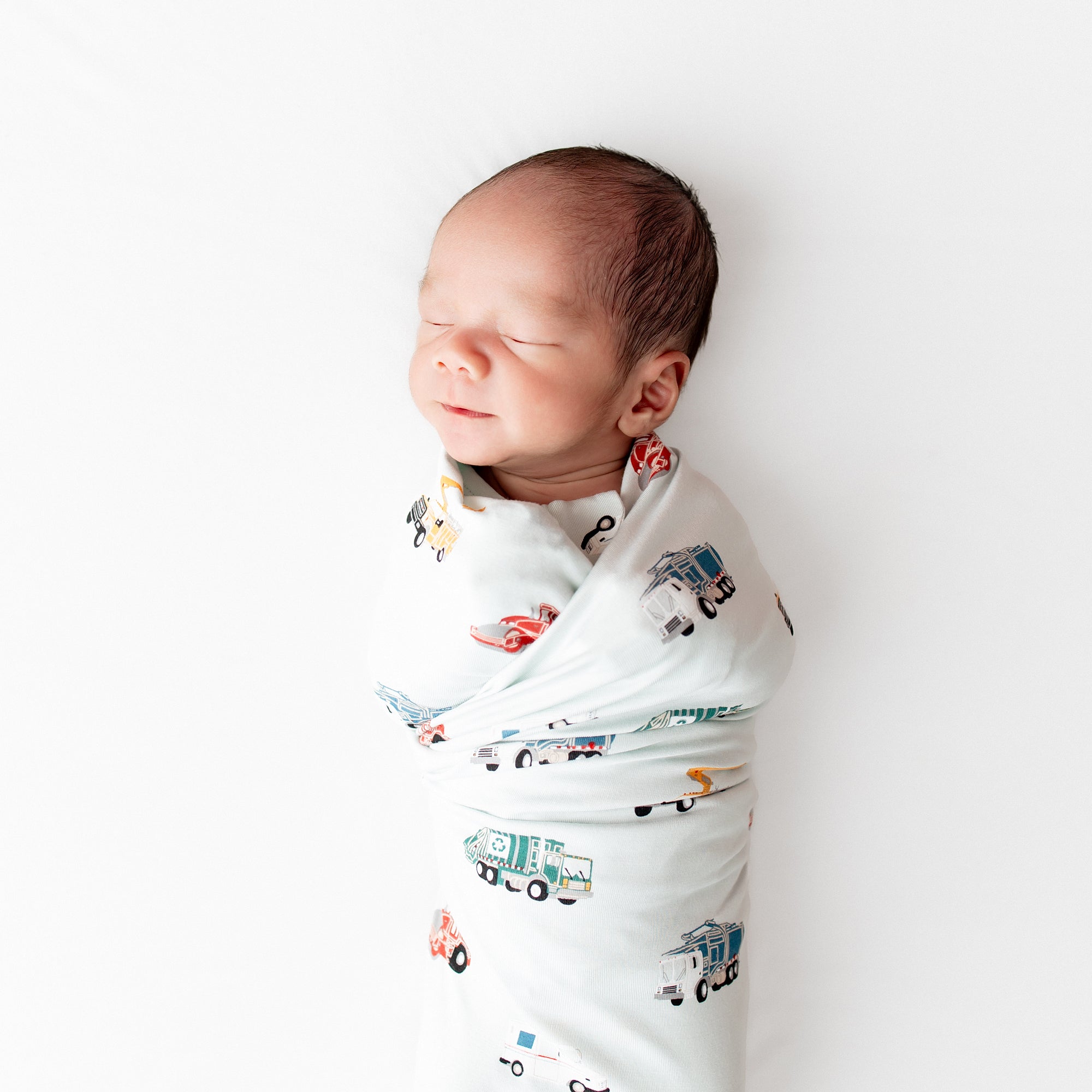 Close up of sleeping newborn swaddled in the Swaddle Blanket in City Vehicles