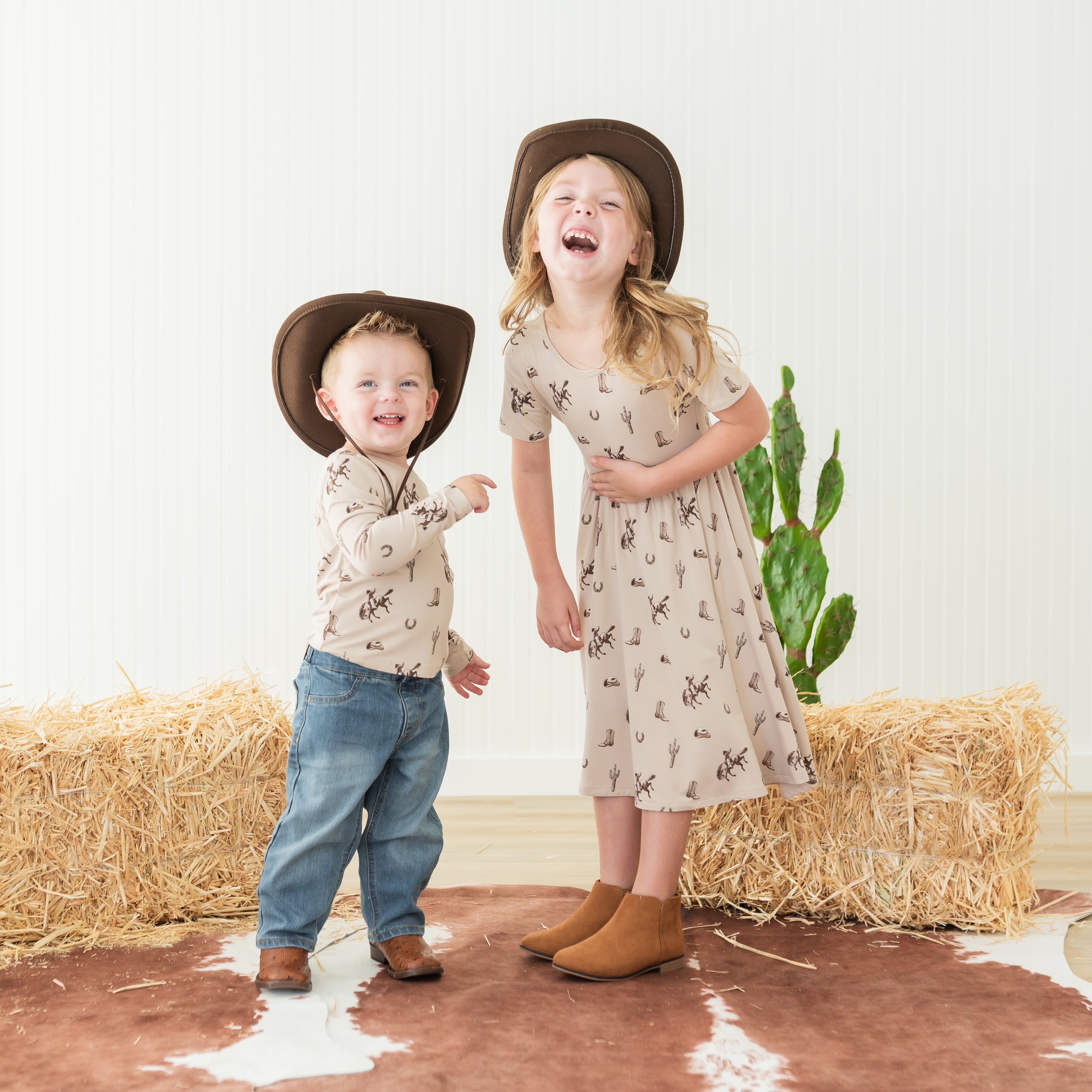 Brother and sister laughing together matching in the classic cowboy print