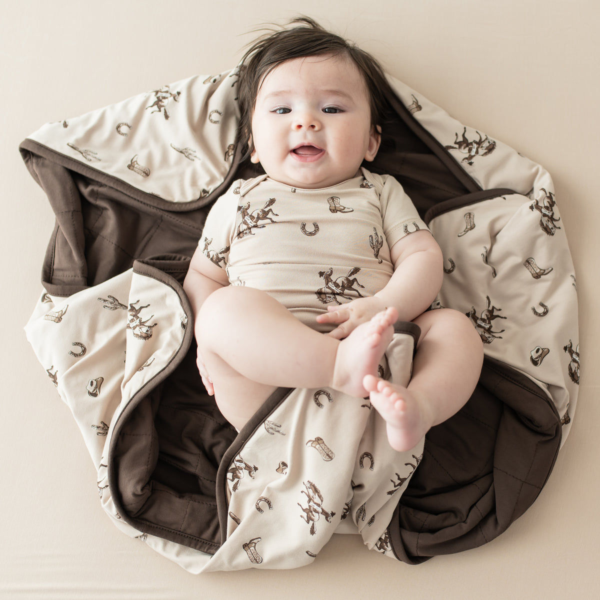 Infant laying on a Baby Blanket in Classic Cowboy wearing a matching short sleeve bodysuit