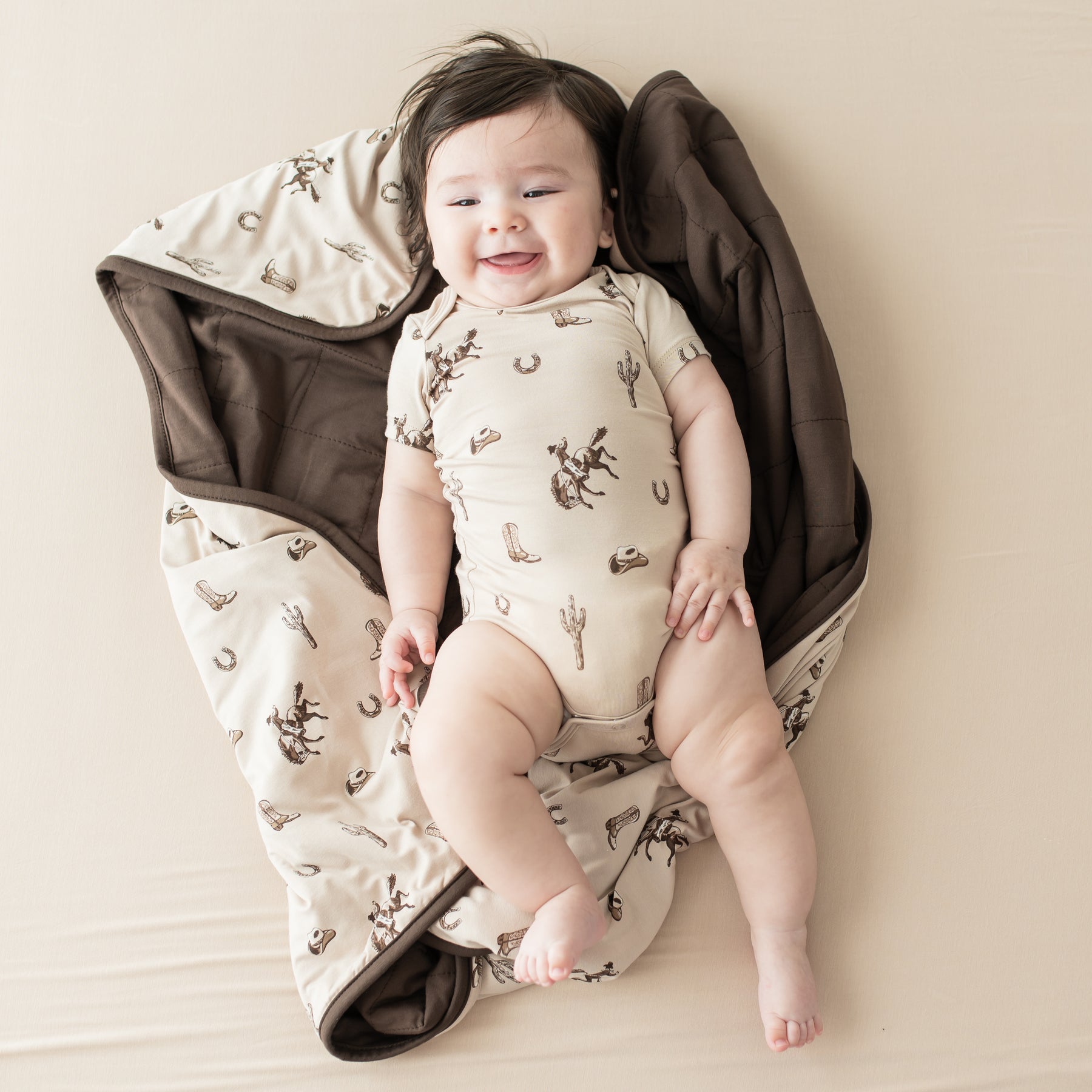 Infant laying on a Baby Blanket in Classic Cowboy wearing a matching short sleeve bodysuit