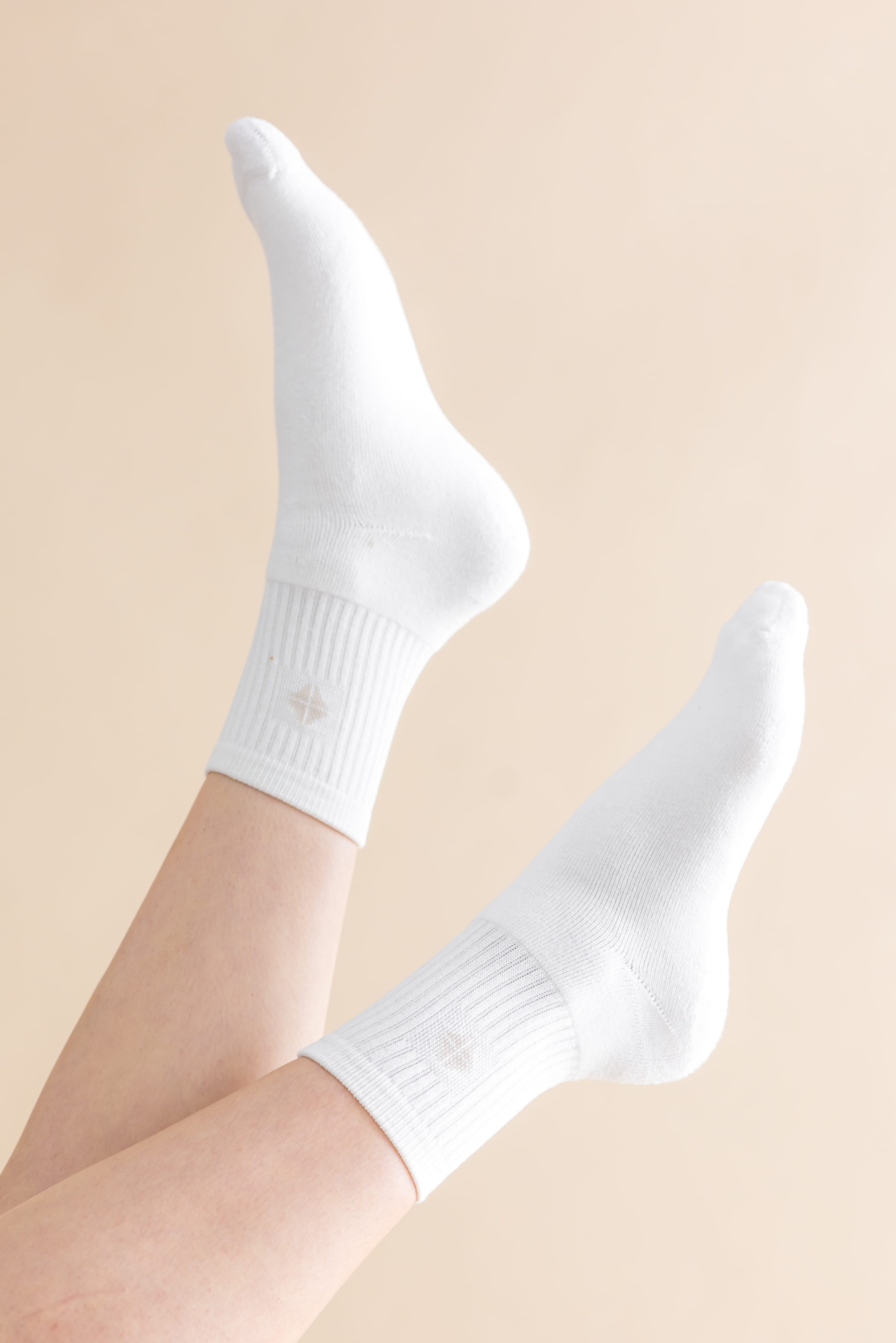 Adult Crew Socks in Cloud shown on models feet in the air with a light cream background