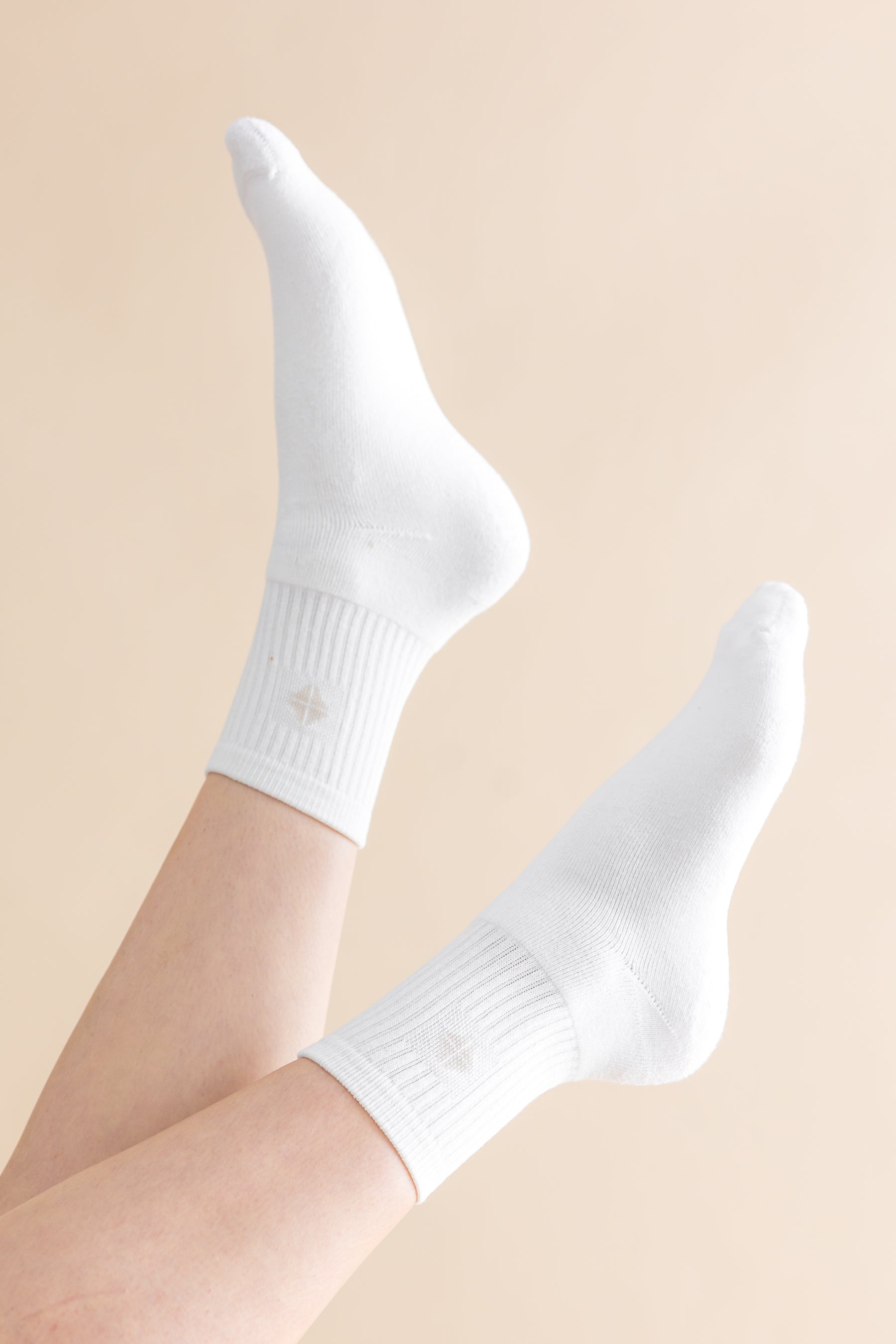 Adult Crew Socks in Cloud shown on models feet in the air with a light cream background