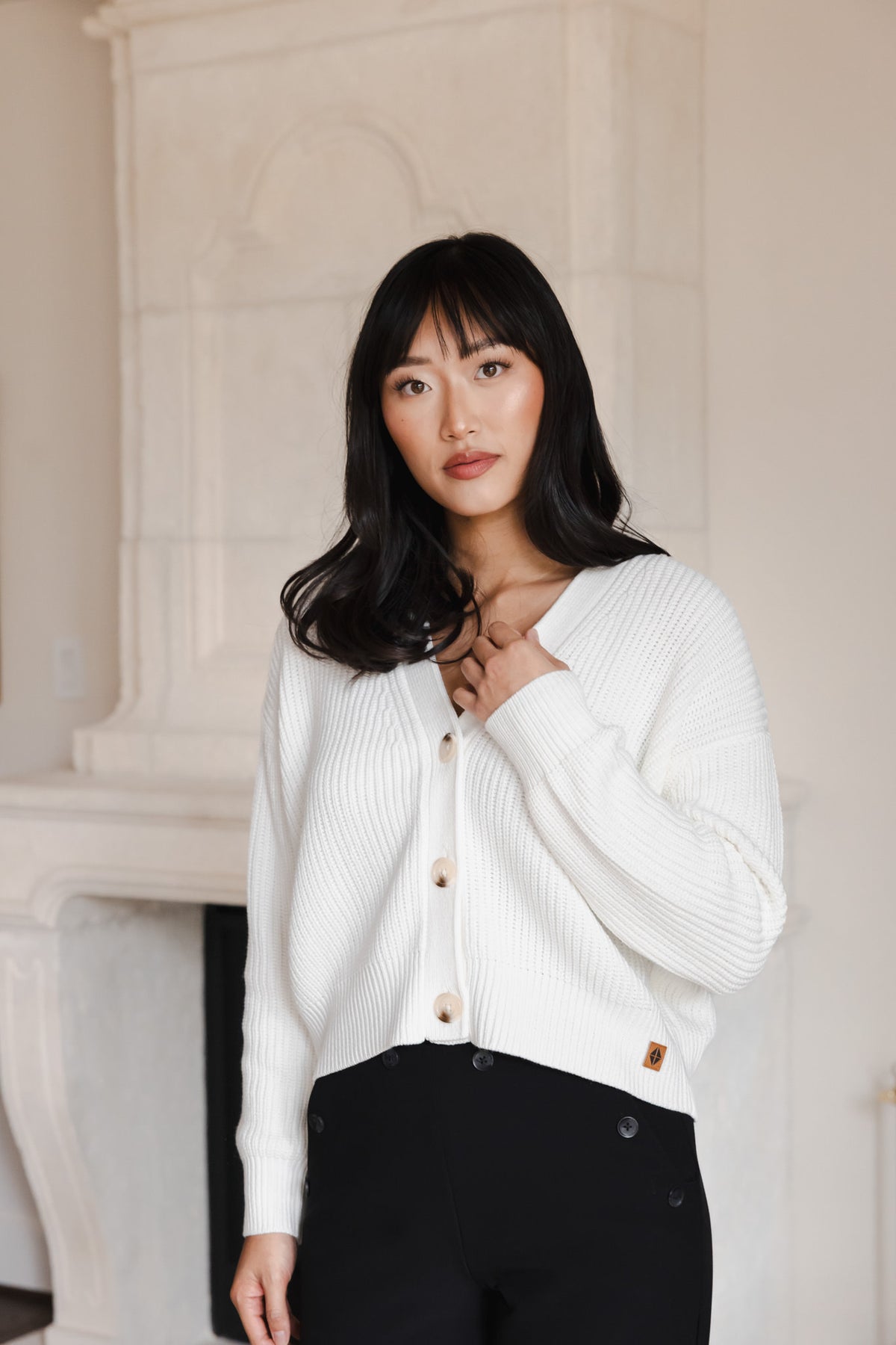 Modal posing in Chunky Knit Women's Cropped Cardigan in Cloud over a black outfit