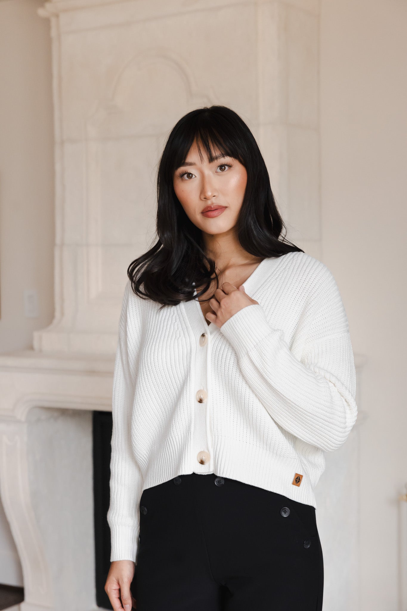 Modal posing in Chunky Knit Women's Cropped Cardigan in Cloud over a black outfit