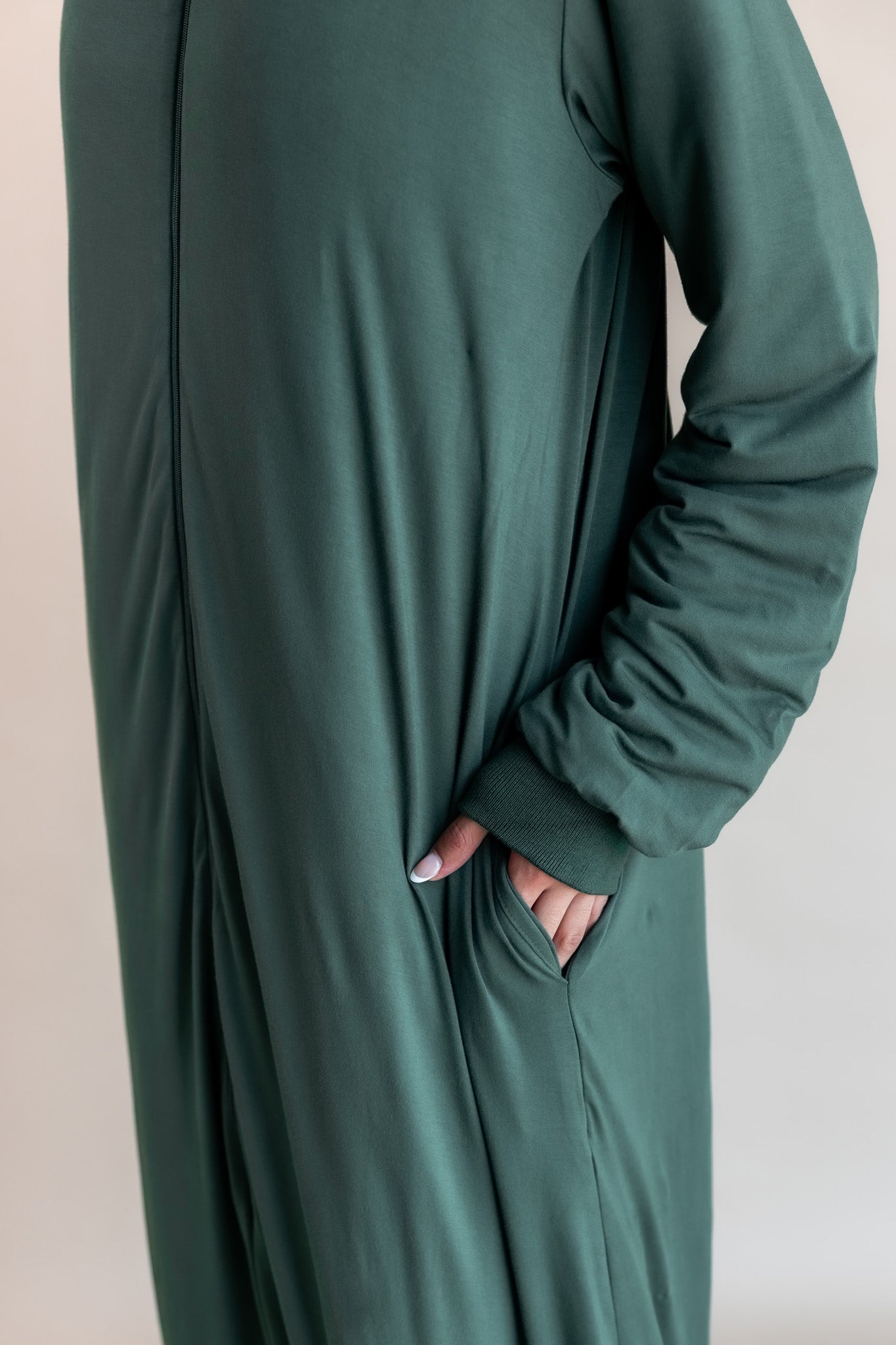 Modal wearing Adult sleep bag walker with sleeves in cypress color on a beige background