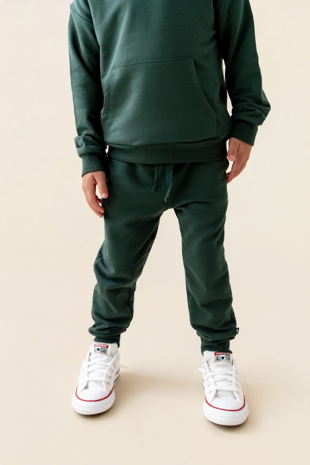 Modal wearing Jogger Pant in Cypress color under cypress color hoodie on a beige background