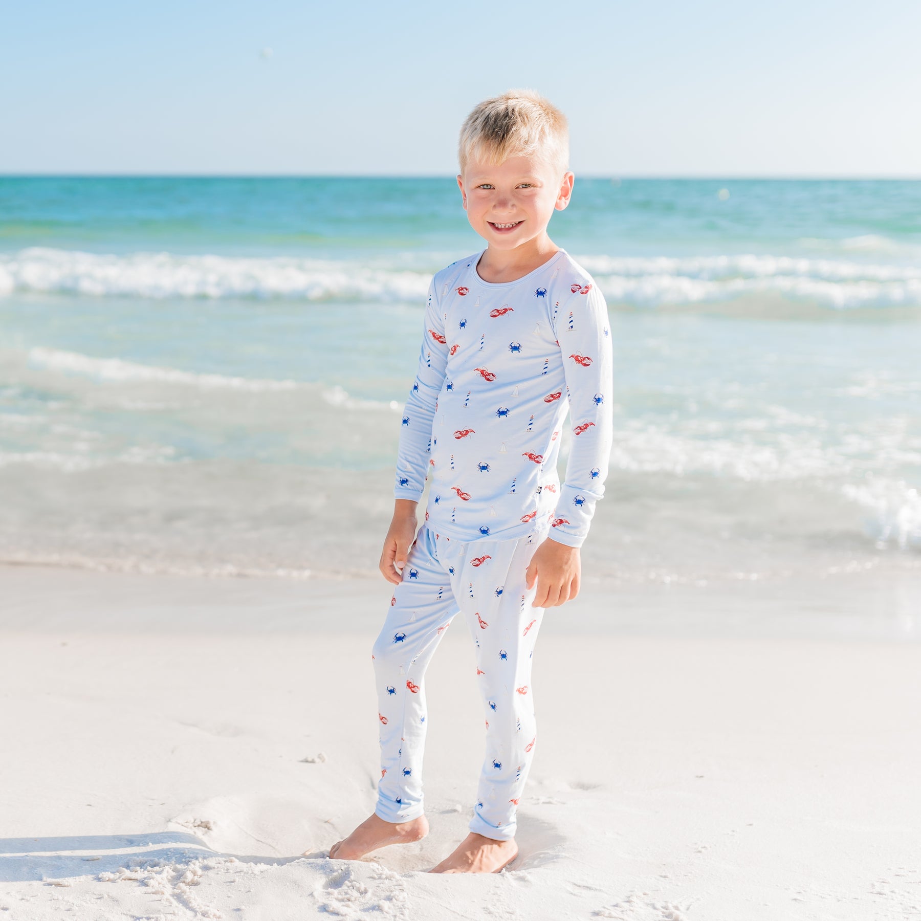 Child wearing a long-sleeve Harbor pajamas on a beach