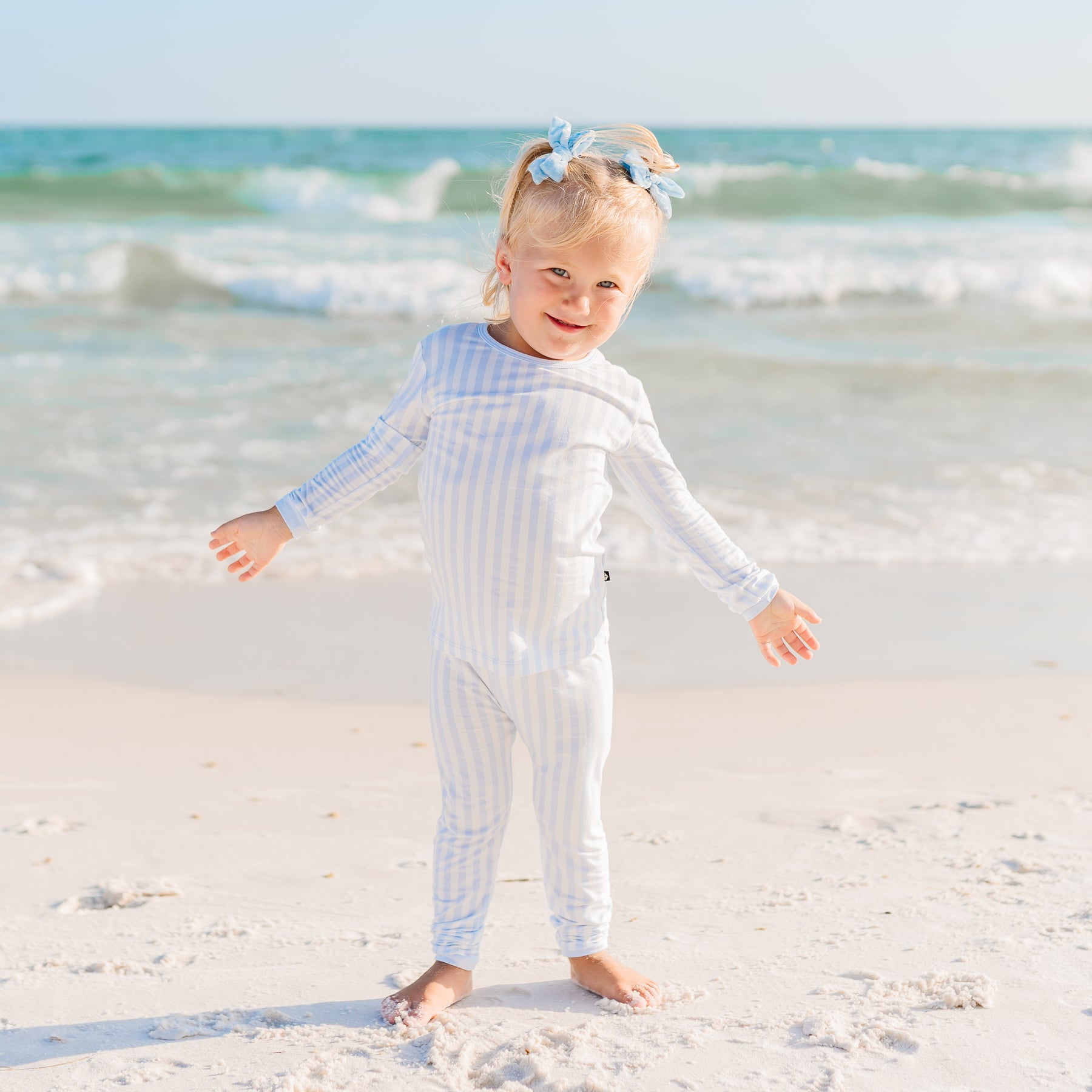 Toddler on the beach wearing mist stripe pajamas