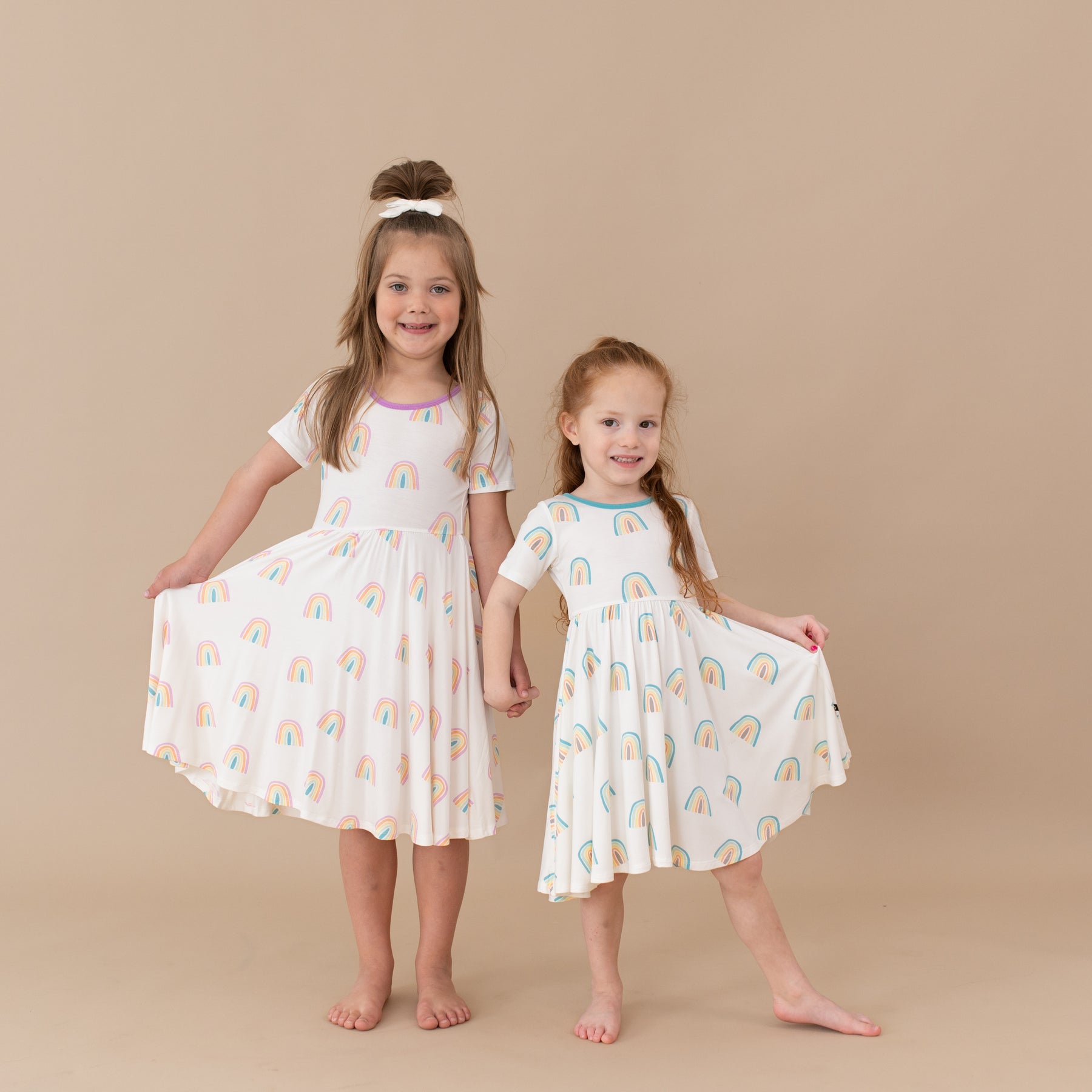 two children modeling poi and makai rainbow twirl dresses