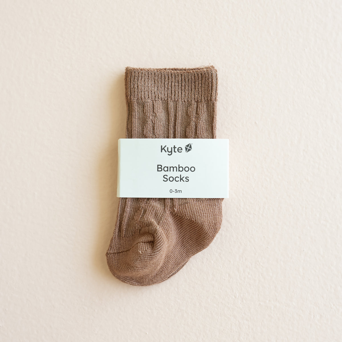 Kyte Baby's Knee High Socks in Latte shown in its packaging