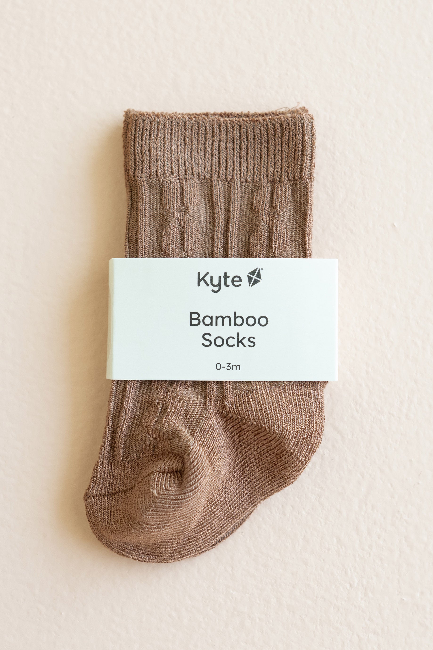 Kyte Baby's Knee High Socks in Latte shown in its packaging