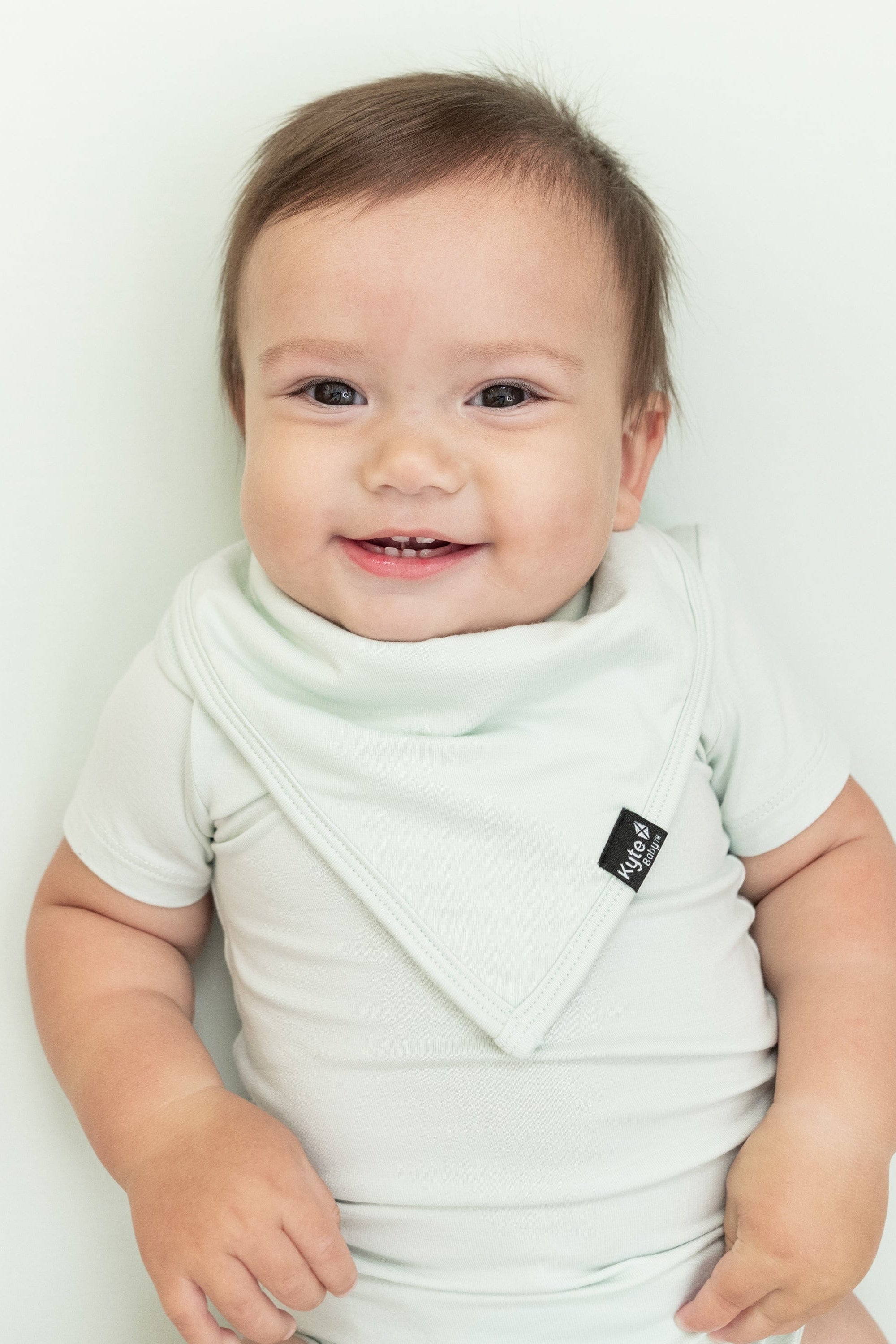 Smiling infant wearing the Bib in Dew with matching bodysuit