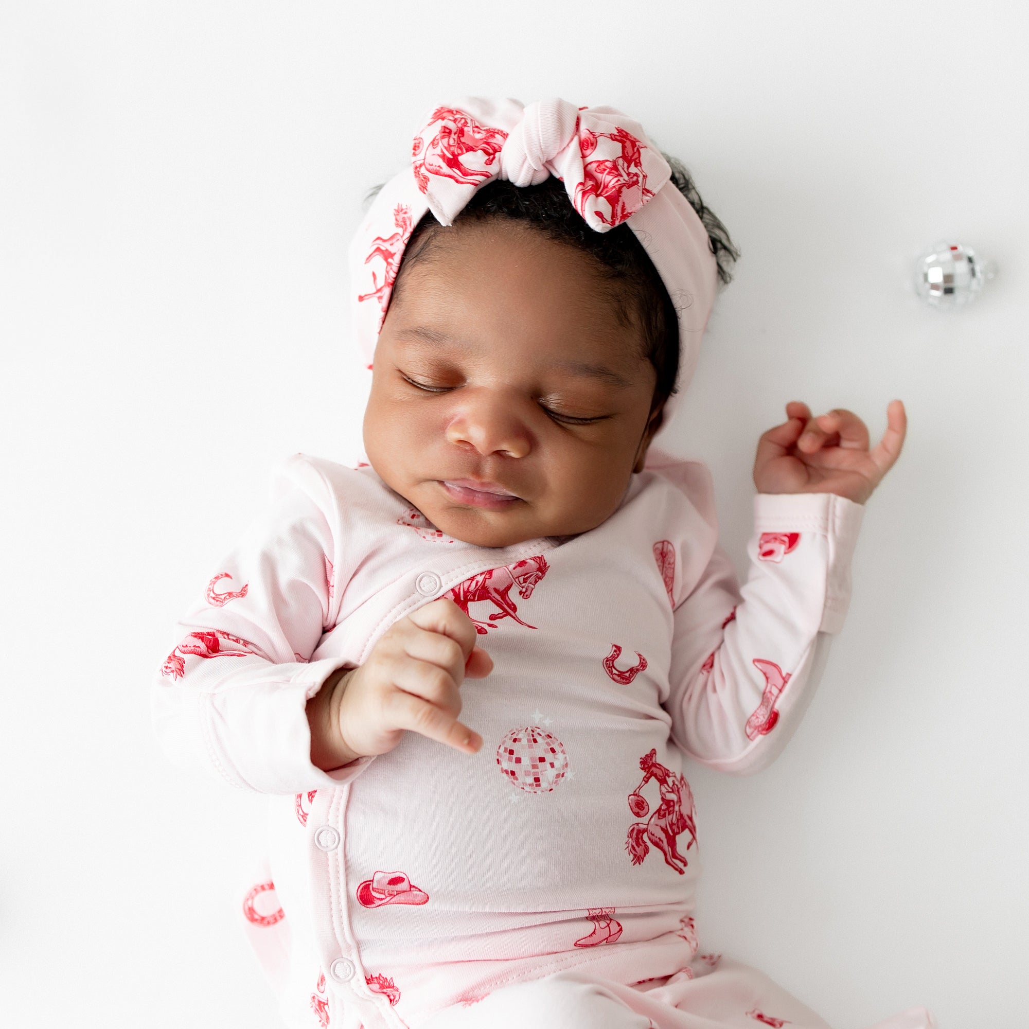Close up of sleeping infant wearing the Take Me Home Set with Bow in Disco Cowgirl