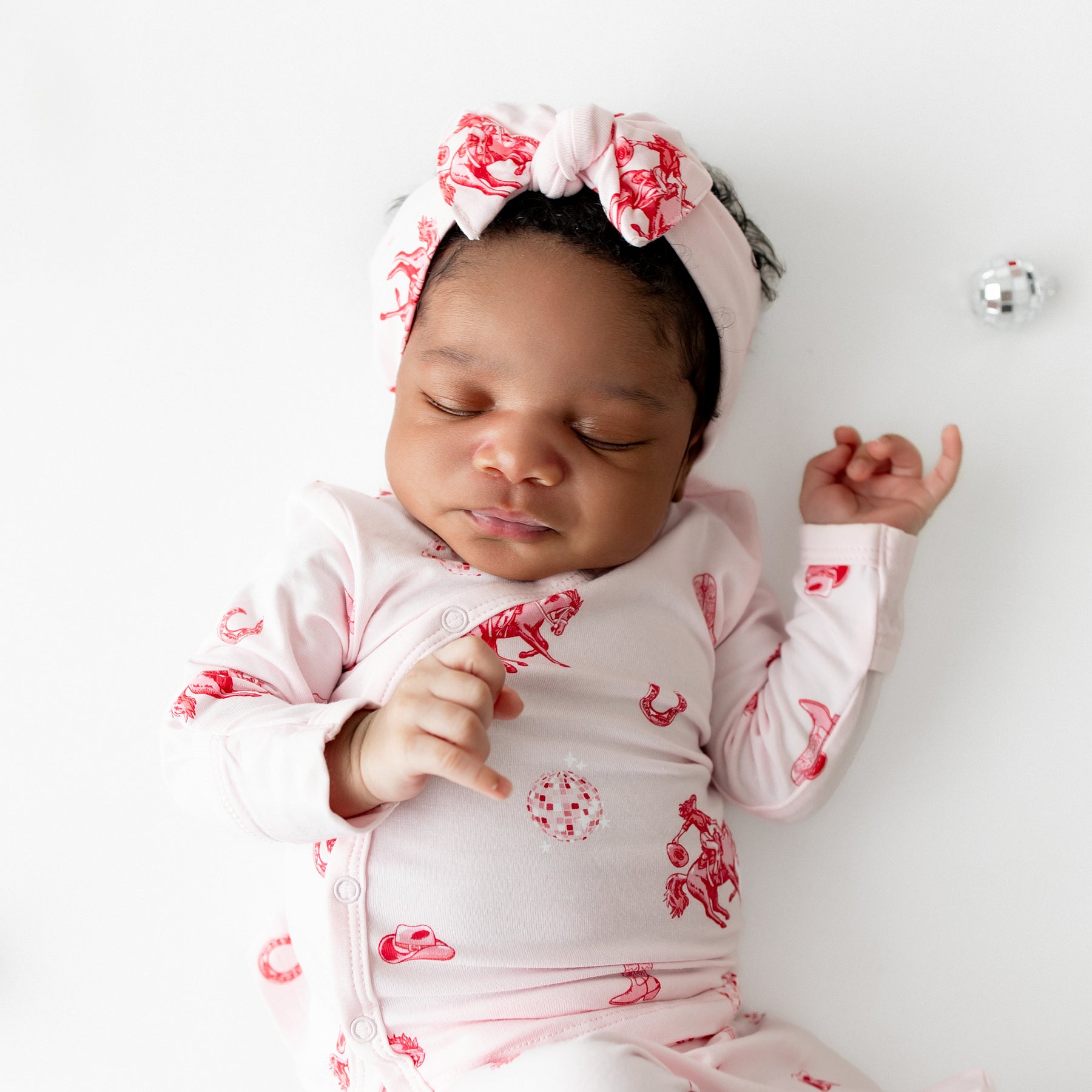 Close up of sleeping infant wearing the Take Me Home Set with Bow in Disco Cowgirl