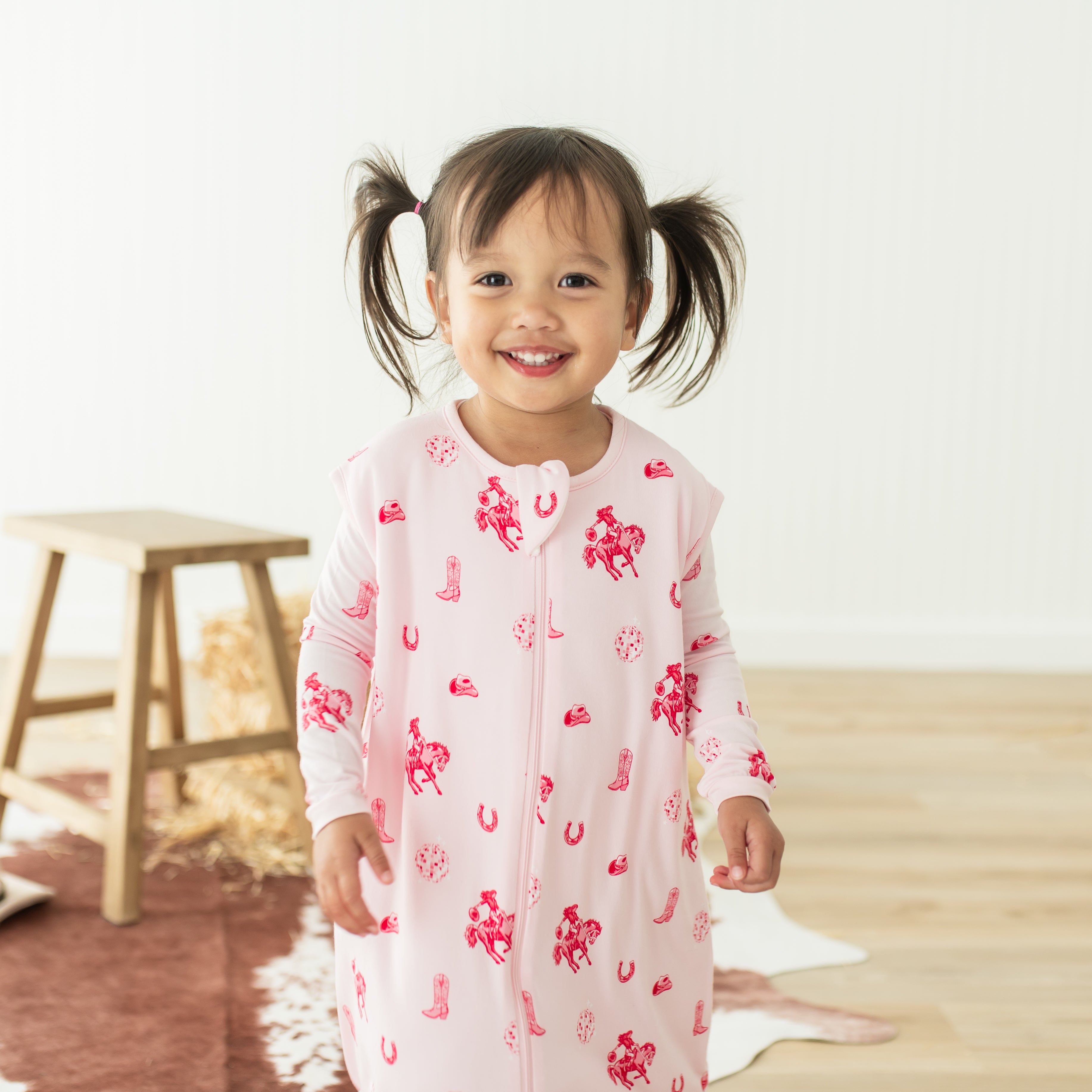 Close up of the Sleep Bag Walker in Disco Cowgirl 1.0 shown on a smiling toddler