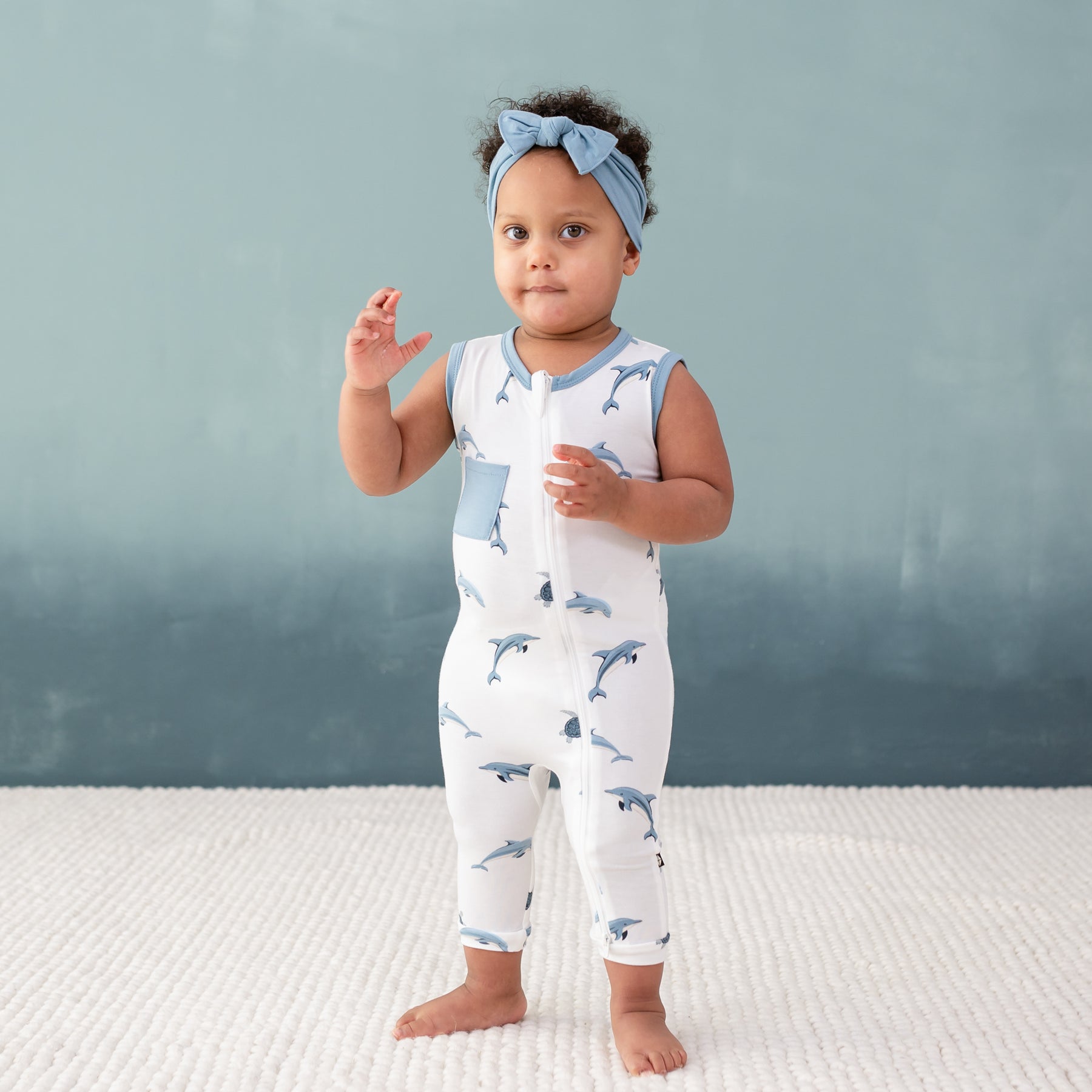 Toddler wearing Zippered Sleeveless Romper in Dolphin and Dusty Blue Bow