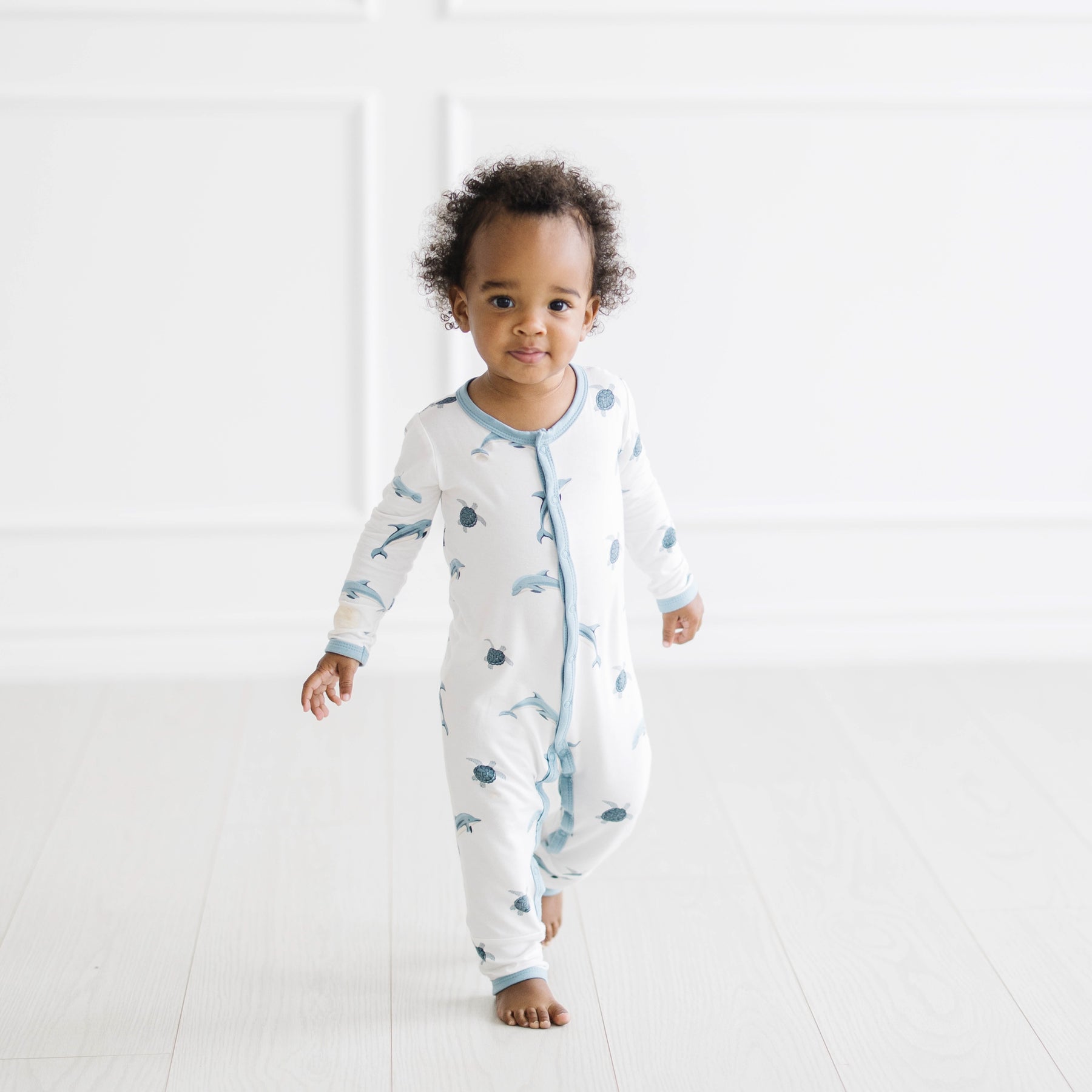 toddler wearing snap romper in dolphin