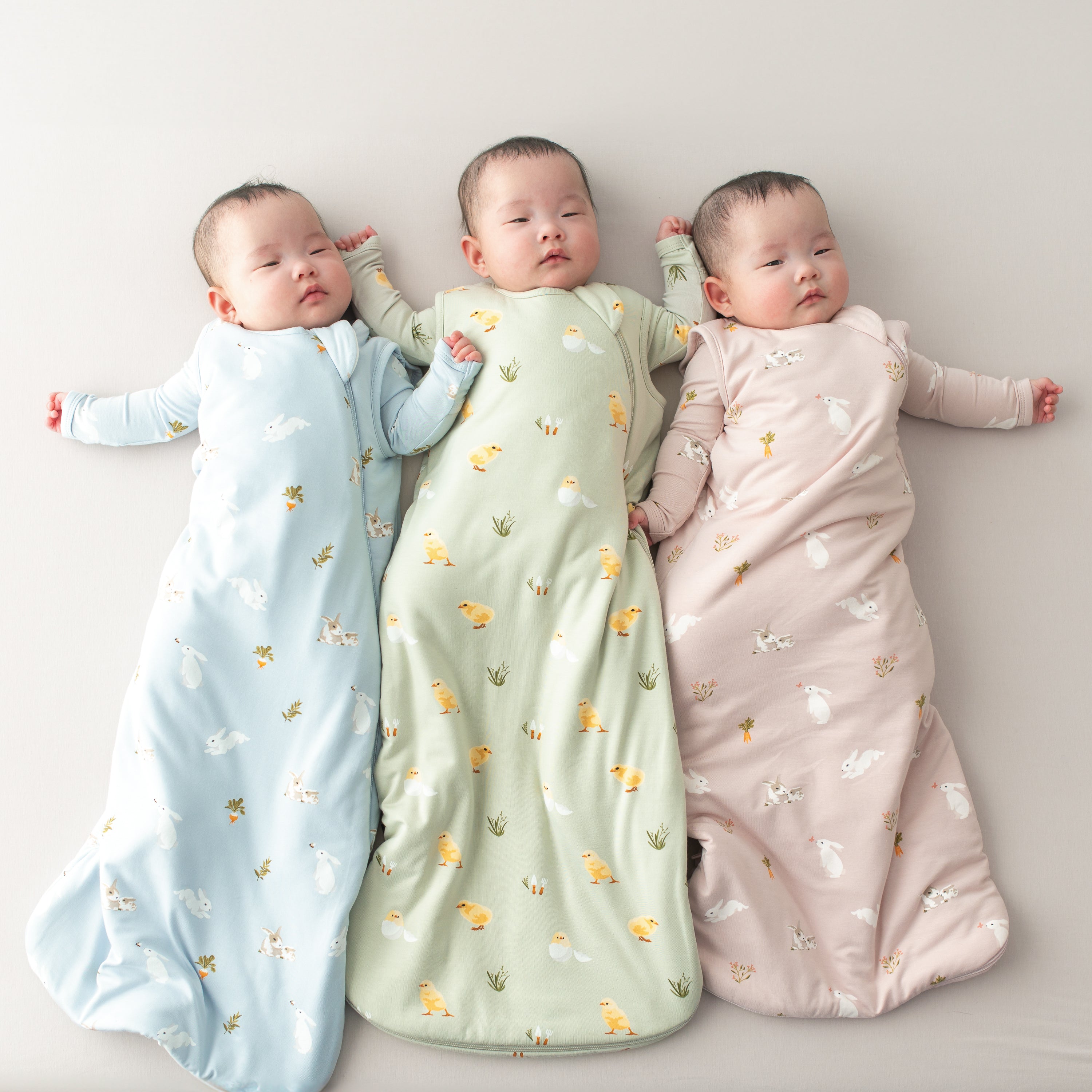 3 babies in sleep bags in easter prints 