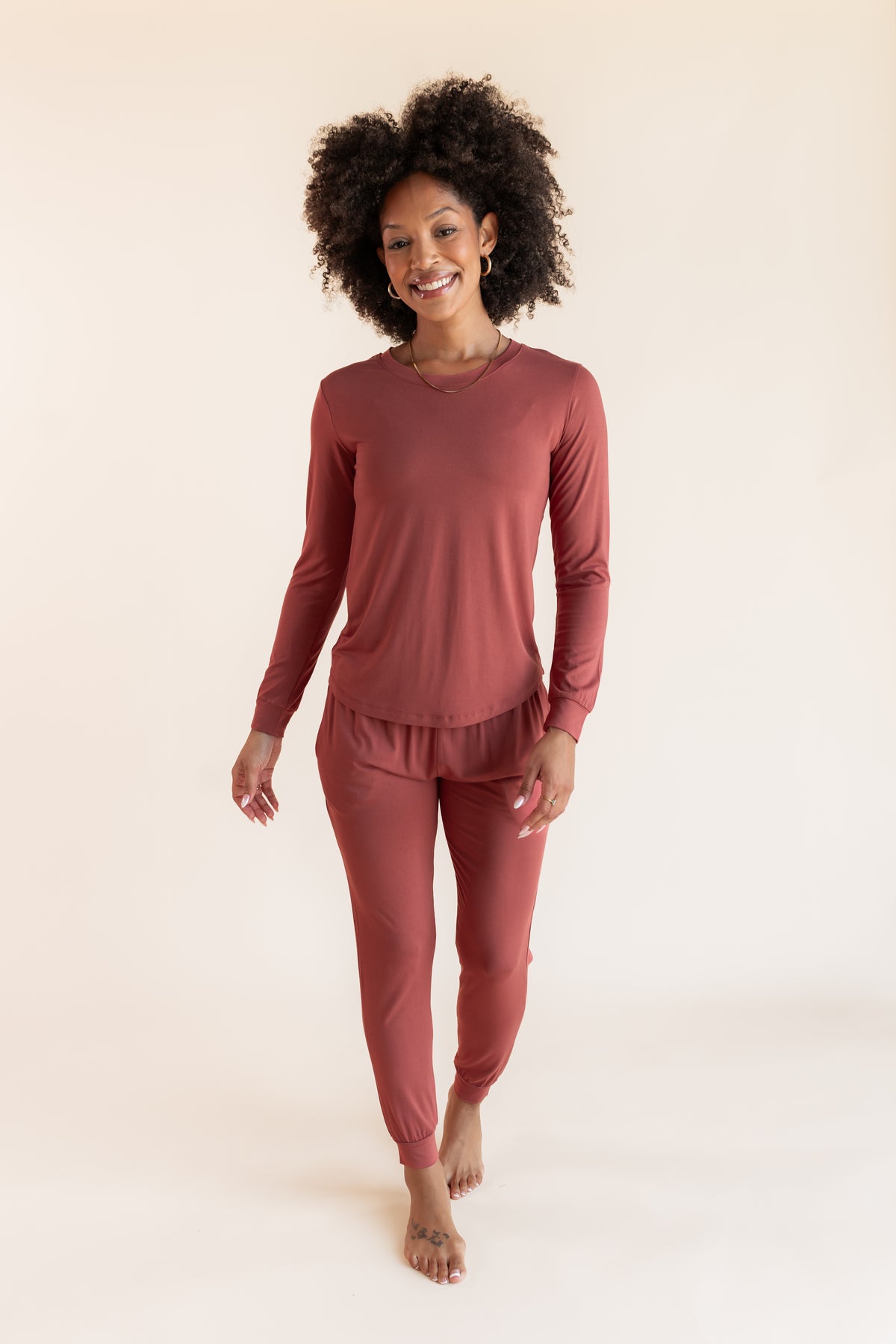 Model wearing Women's Jogger Pajama Set in Ember on a beige background