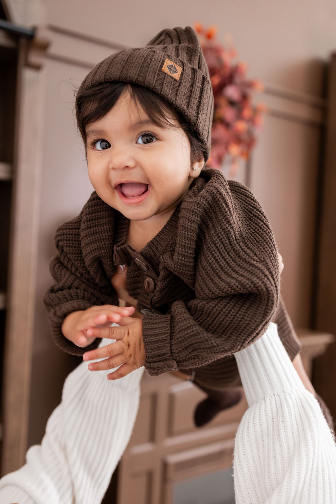Baby wearing wearing Chunky knit romper under Chunky knit ribbed beanie  in Espresso