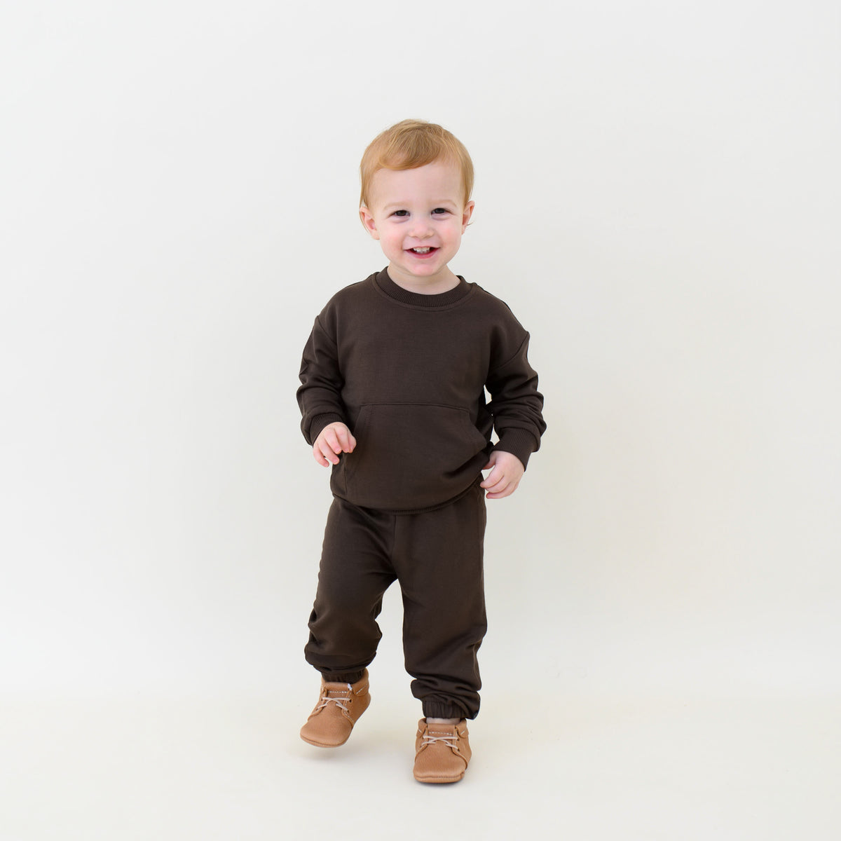 Young smiling boy walking wearing the French Terry Jogger Set in Espresso