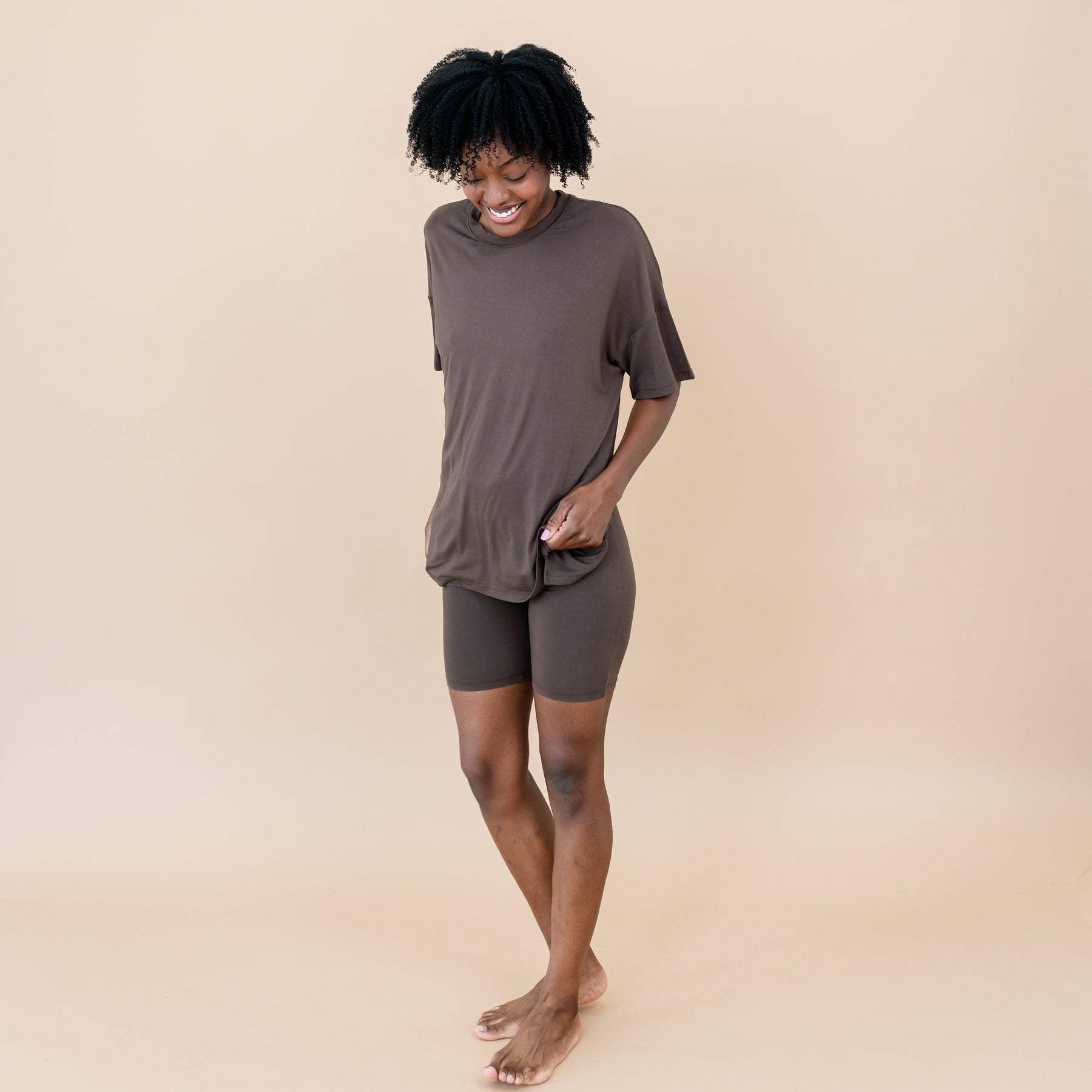 Female standing looking down at her feet wearing the Women’s Biker Short Set in Espresso