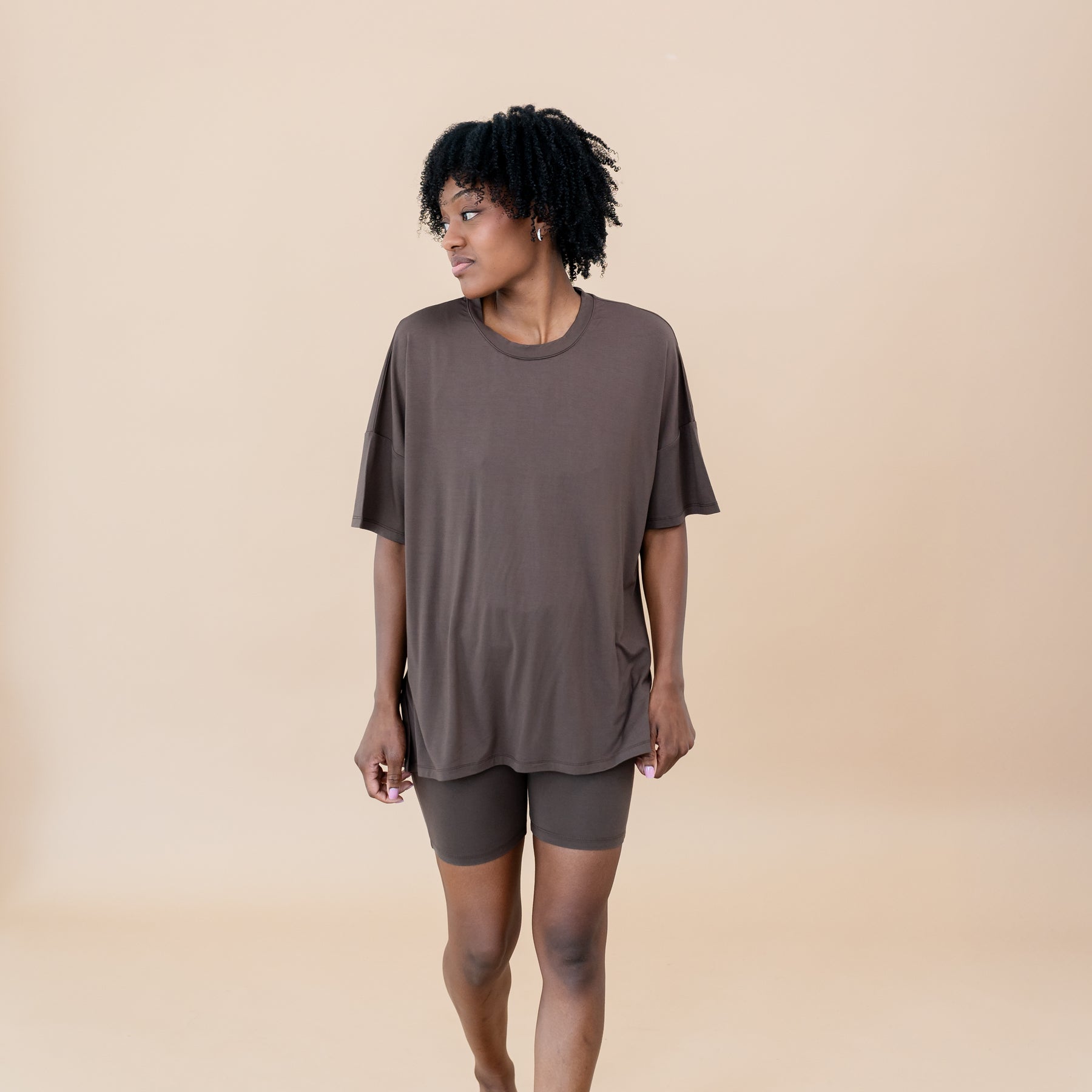 Female model looking off to the side wearing the Women’s Biker Short Set in Espresso