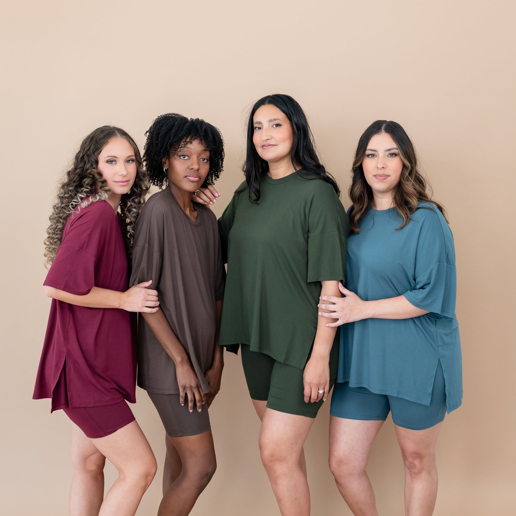 Four female models wearing the Women’s Biker Short Set in Burgundy, Espresso, Fir and Atlantic