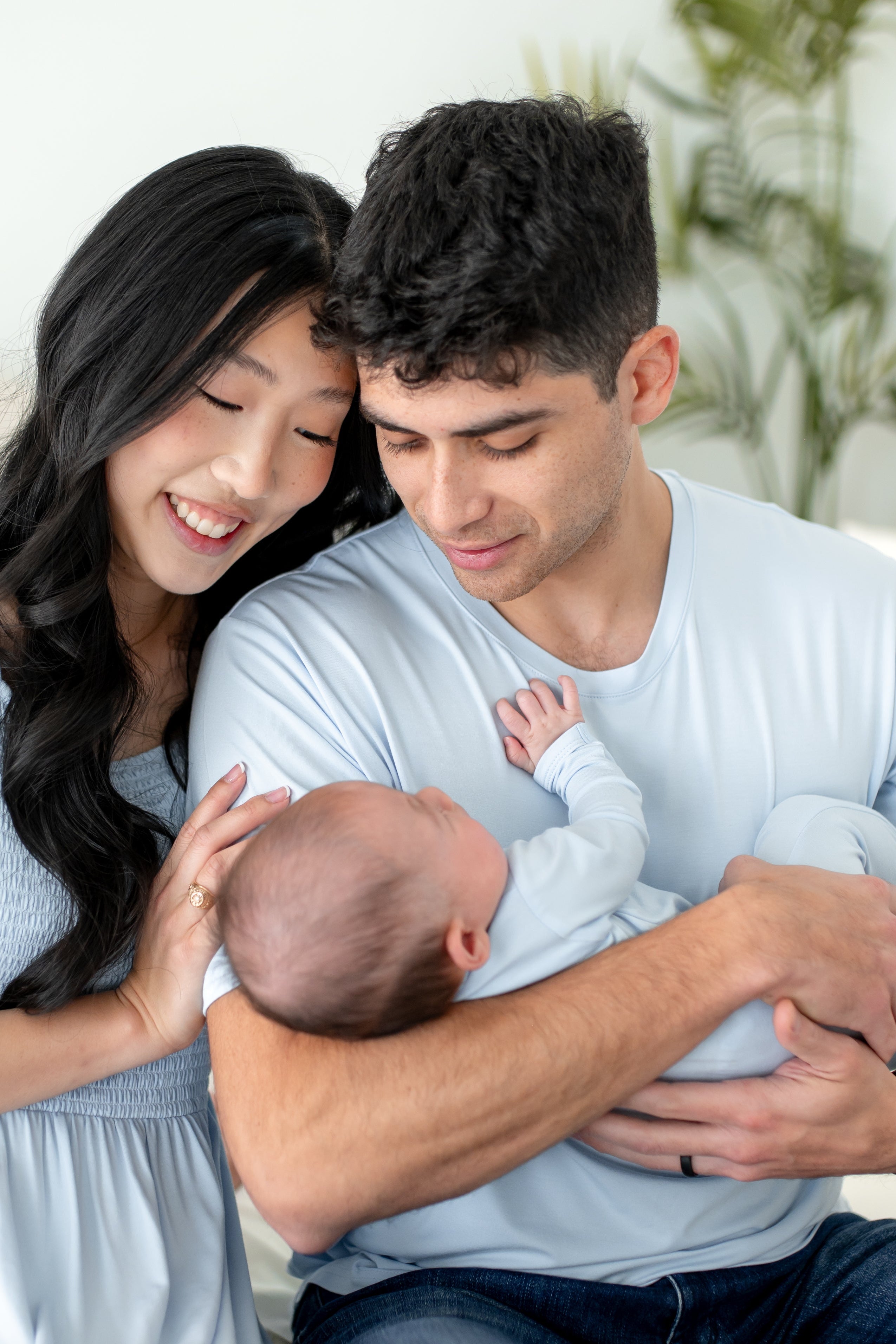 Family of 3 wearing matching blue outfits
