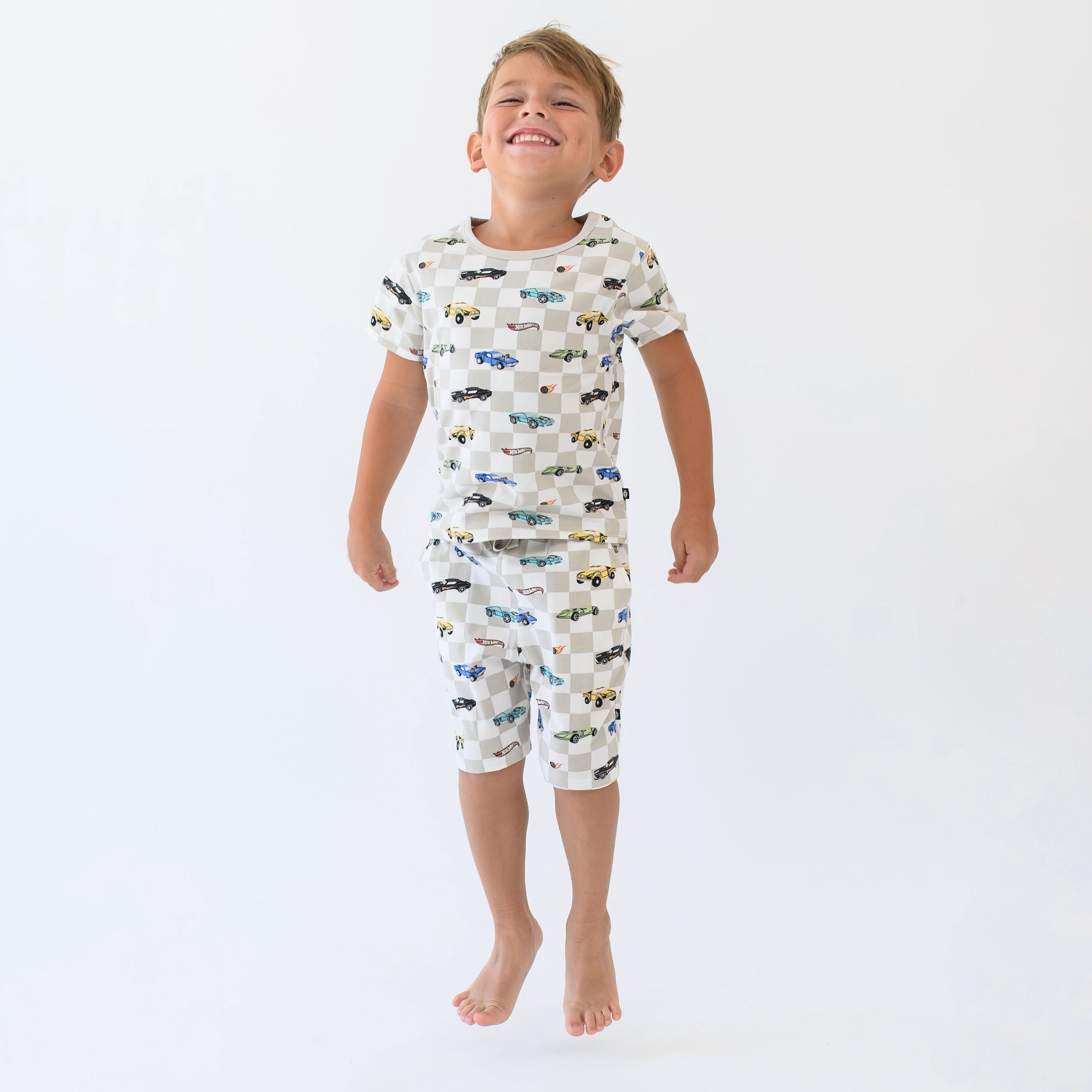 Young smiling boy jumping wearing the Short Sleeve Pajamas in Fast and Fierce