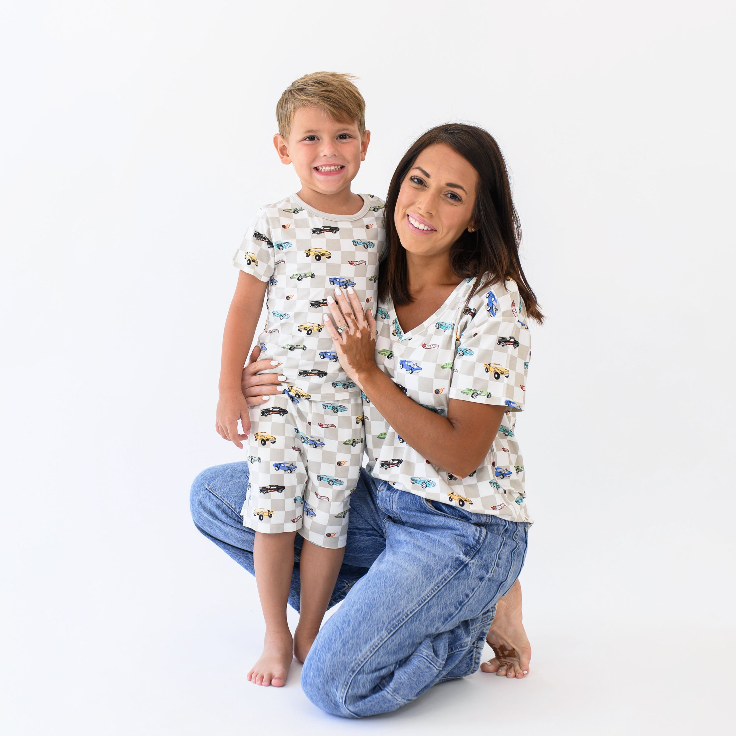 Mother and son matching in Fast and Fierce. Young boy is being hugged by his mother wearing the Short Sleeve Pajamas in Fast and Fierce while mother is kneeling wearing the women's vneck
