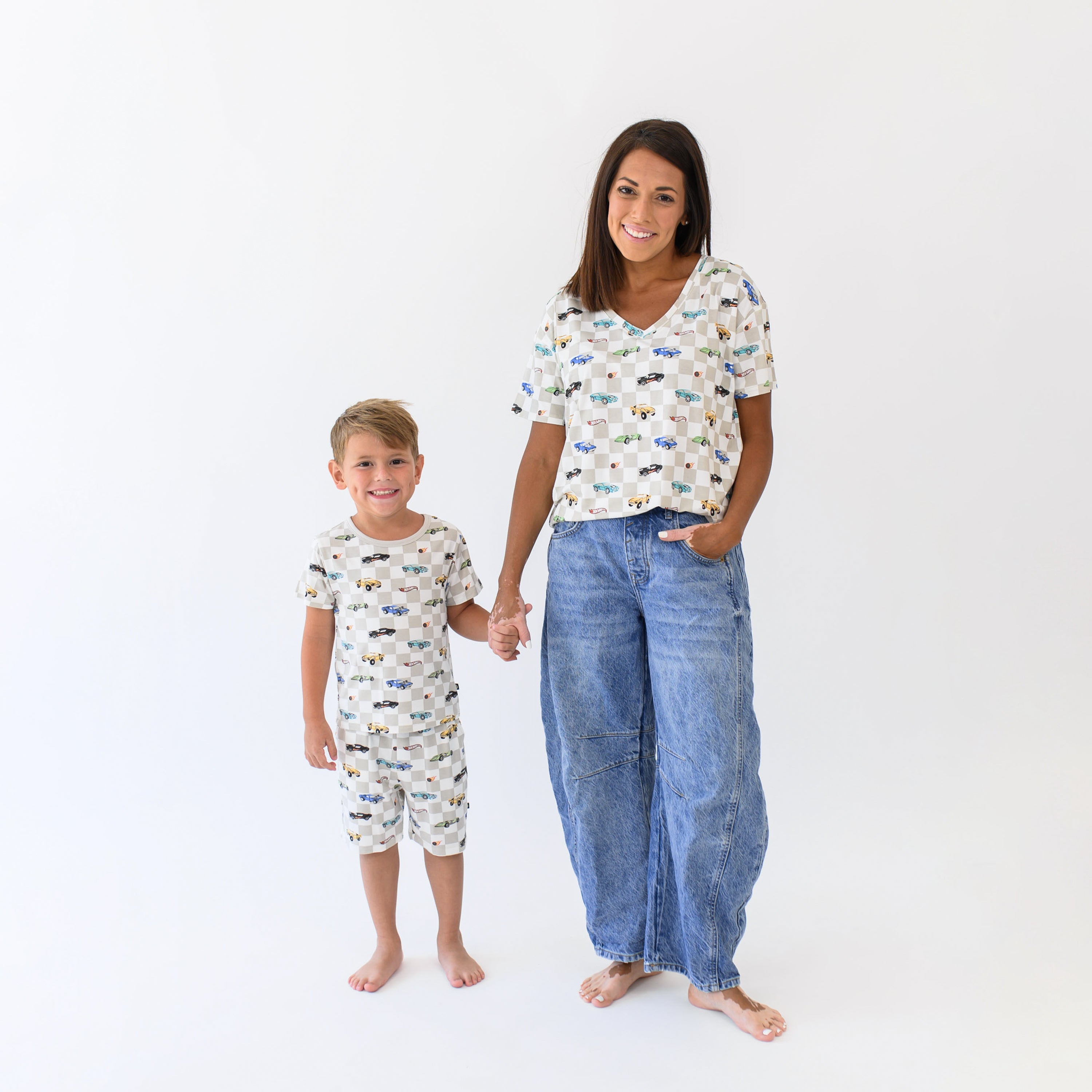 Woman modeling Women's Relaxed Fit V-Neck in Fast and Fierce with jeans holding hands with young boy wearing matching short sleeve pajamas