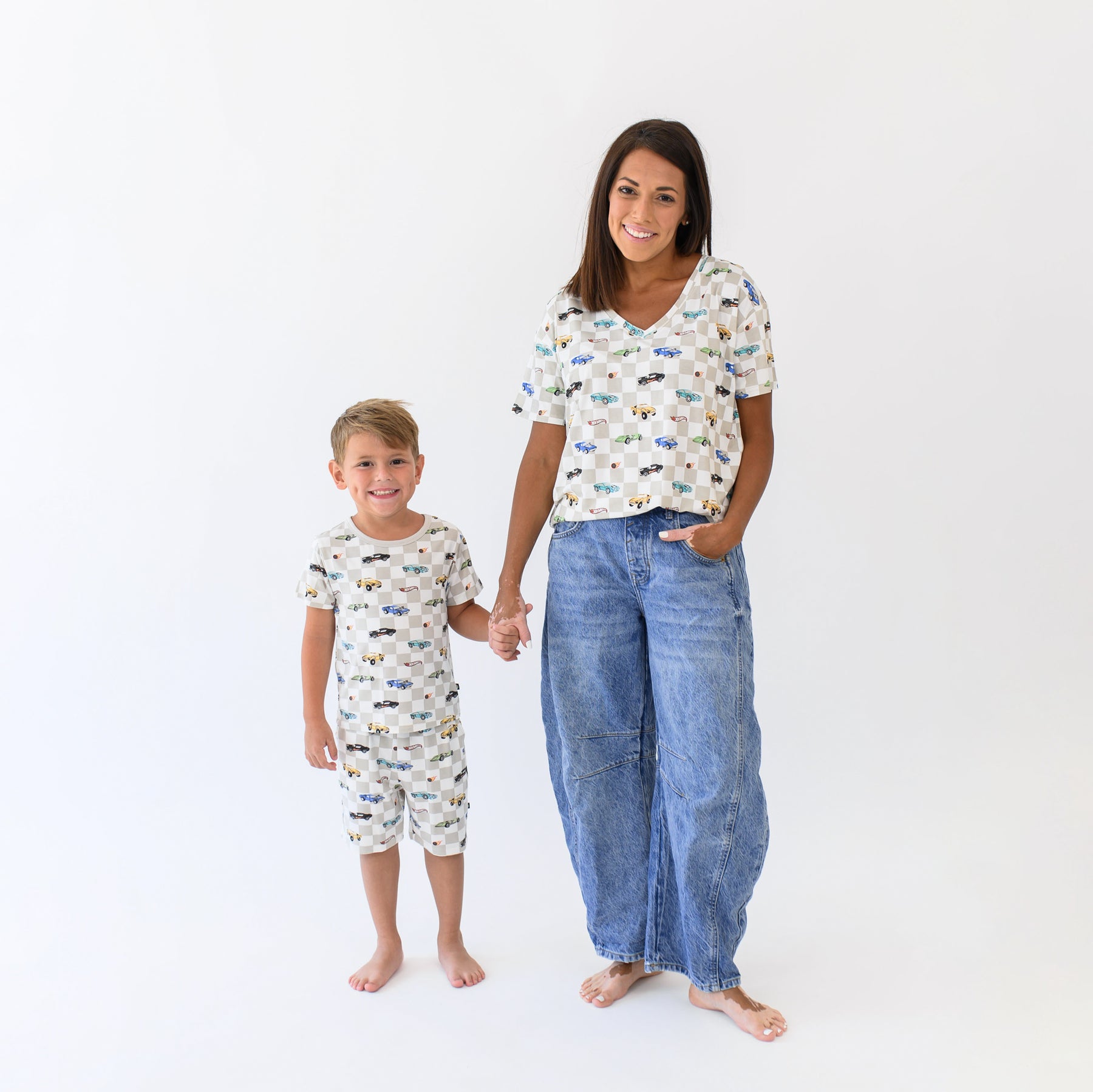 Woman modeling Women's Relaxed Fit V-Neck in Fast and Fierce with jeans holding hands with young boy wearing matching short sleeve pajamas