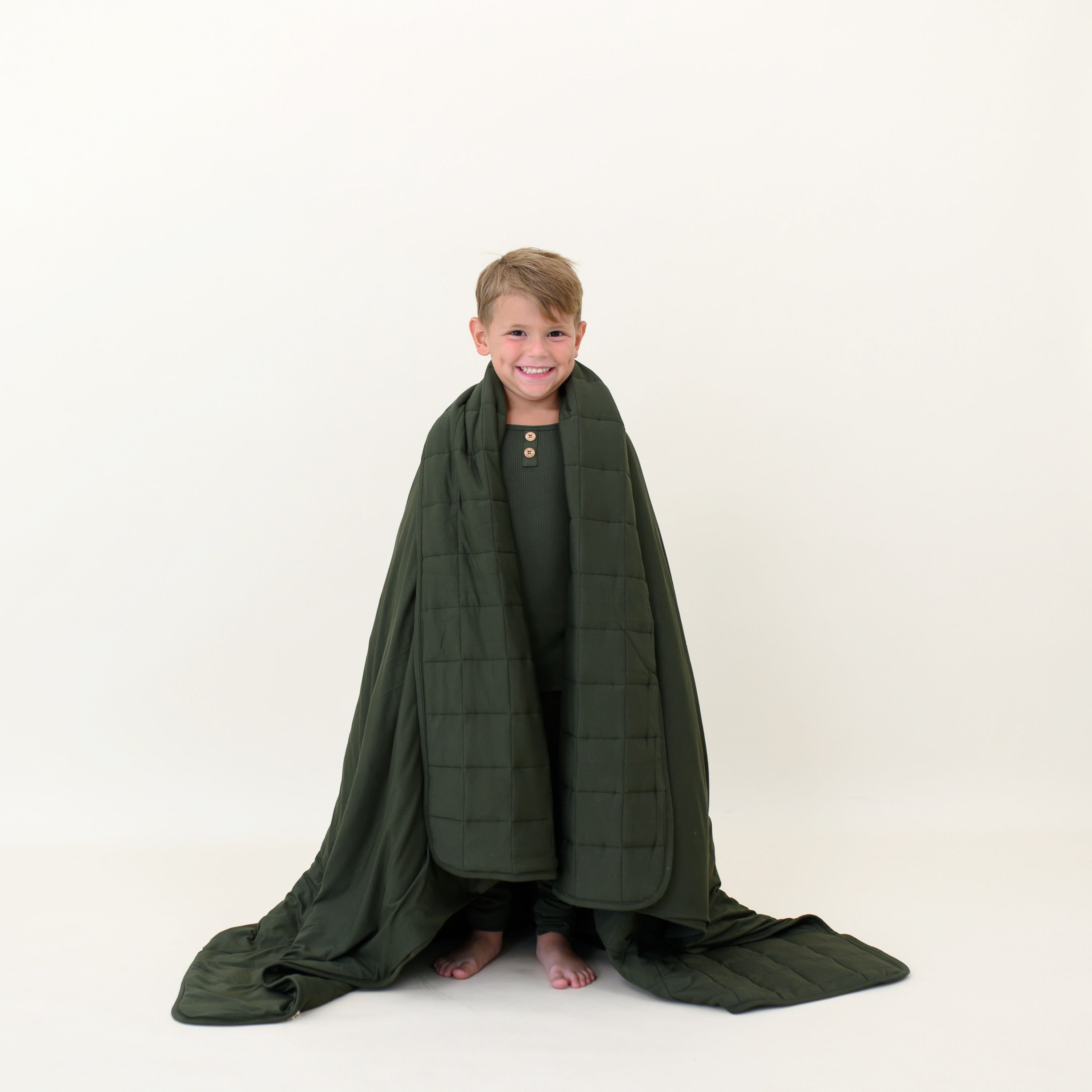Child wearing a matching henley set and wrapped in a Youth Blanket in Fir 2.5