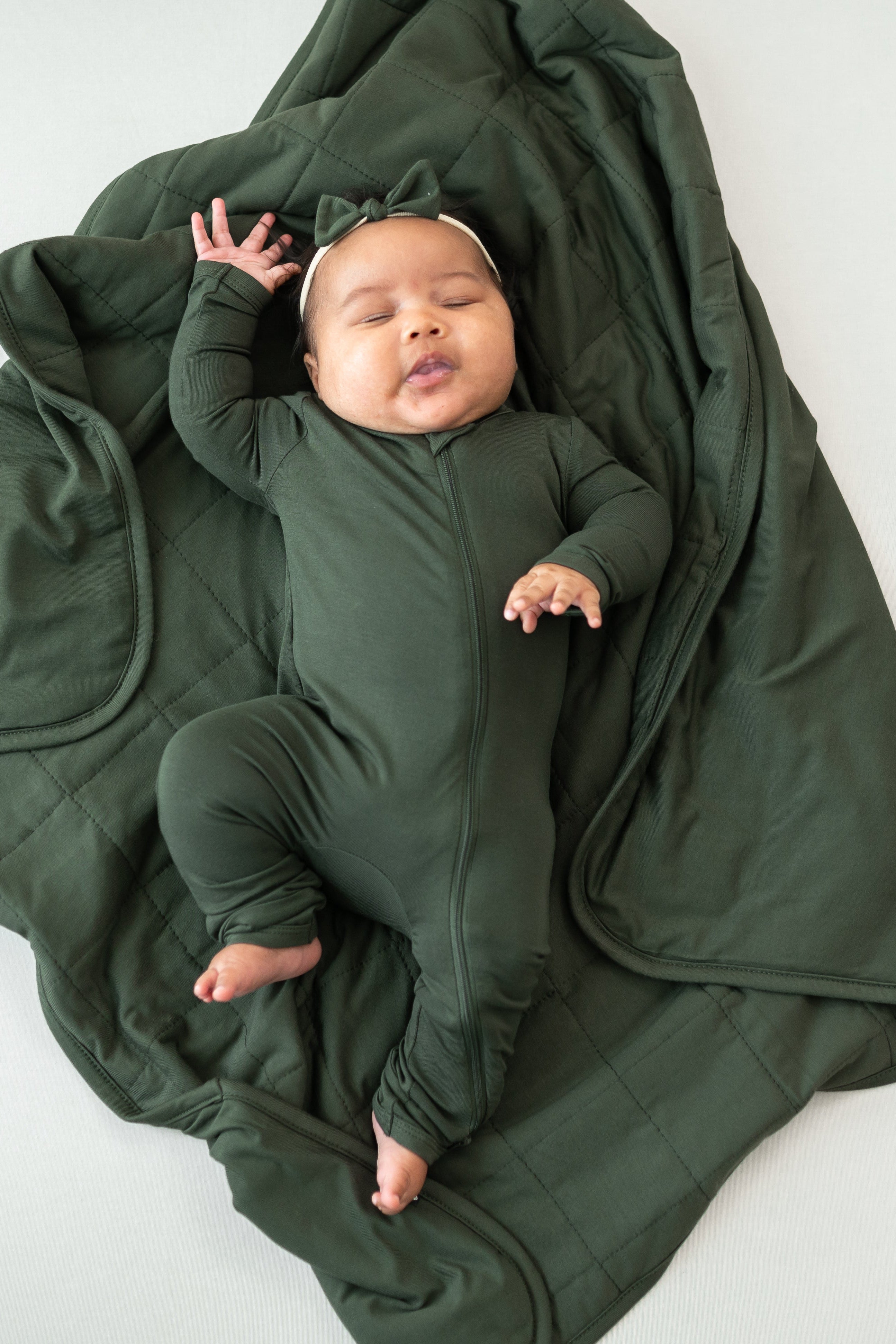 Baby wearing Fir Zippered Romper laying on Baby Blanket in Fir 1.0