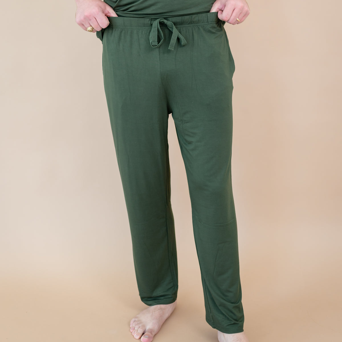 Men's Lounge Pants in Fir worn by a person on a beige background