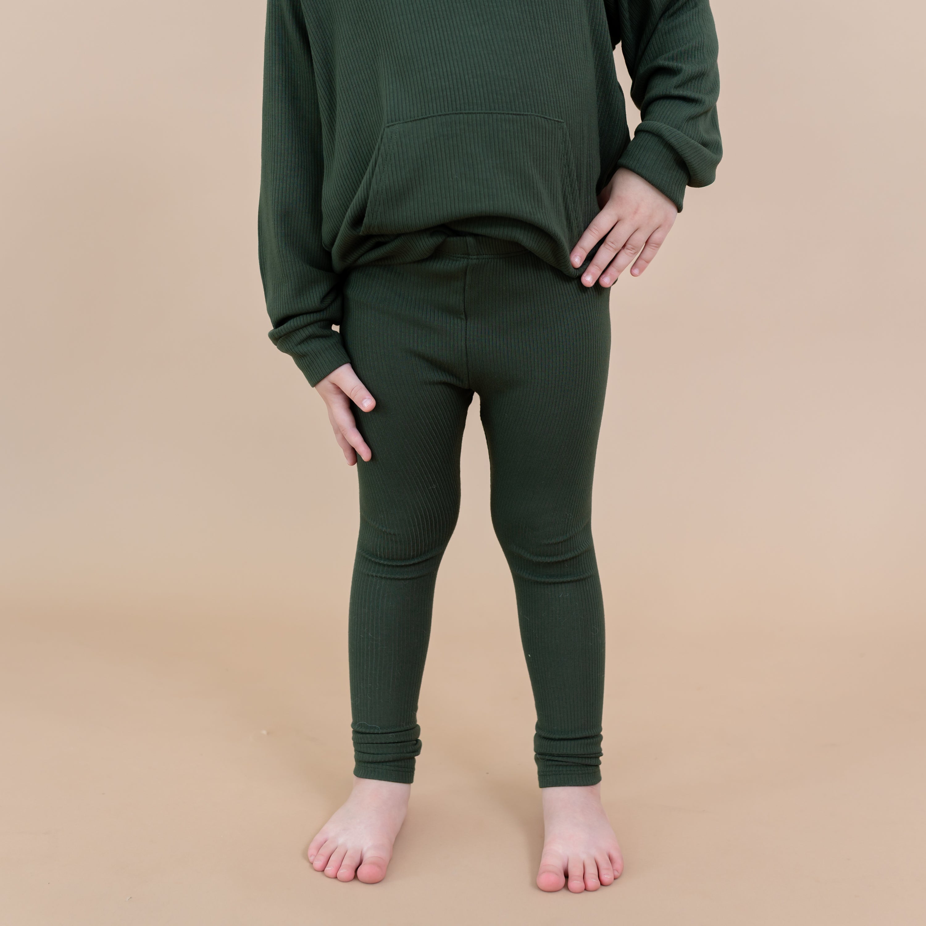 The Ribbed Leggings in Fir shown on a young girl model